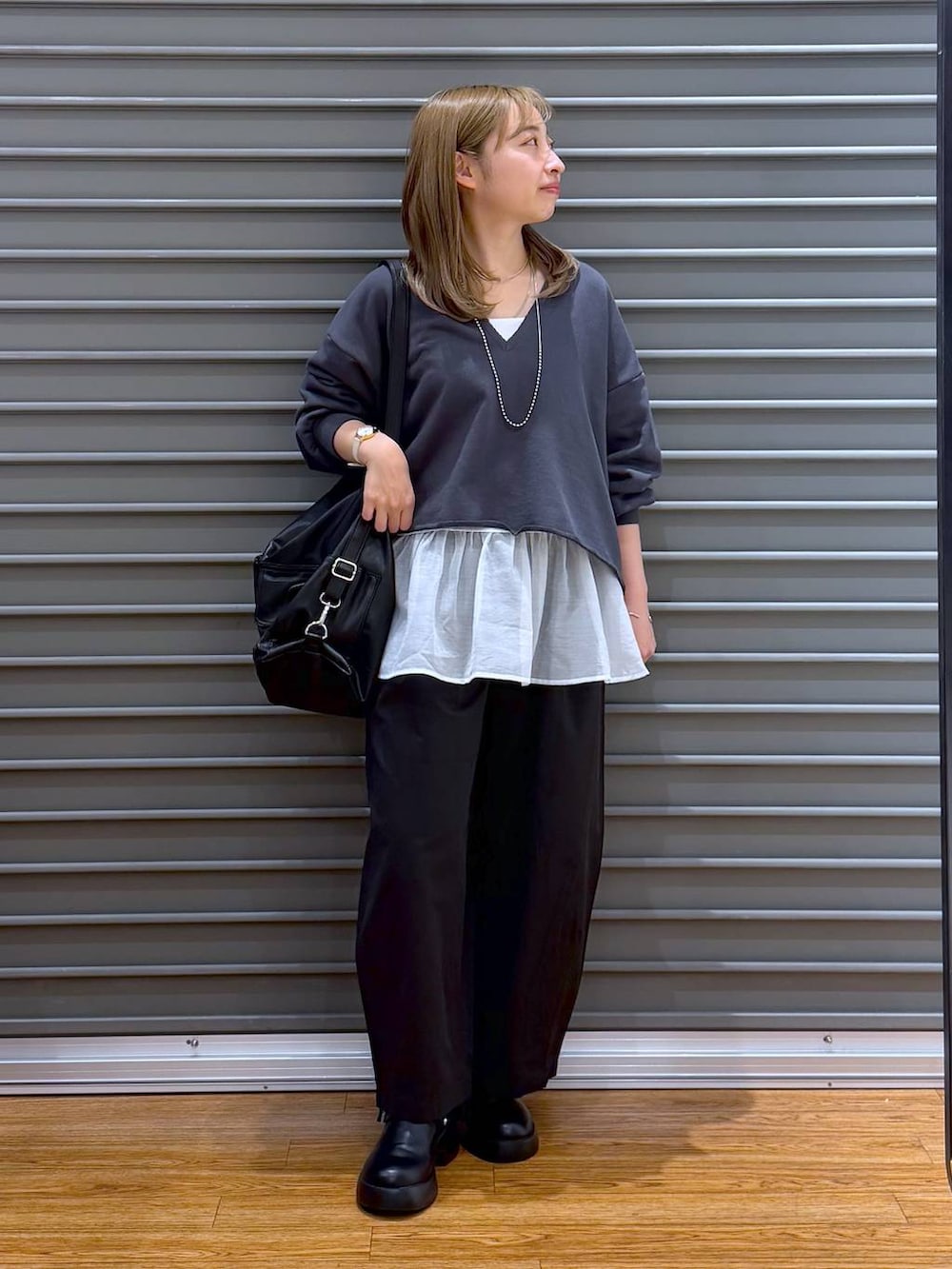 ブラック系のサンダル、ブラック系のショルダーバッグ、ホワイト系のキャミソールを着用したレディースの春コーディネートの5枚目の写真