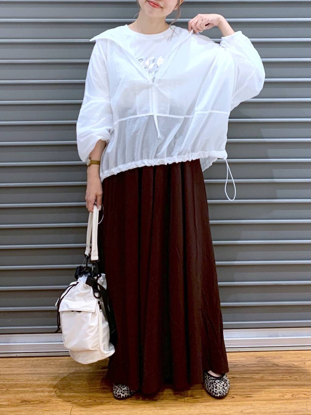 ホワイト系のショルダーバッグ、ブラウン系のスカート、その他のバレエシューズを着用したレディースの秋コーディネートの4枚目の写真