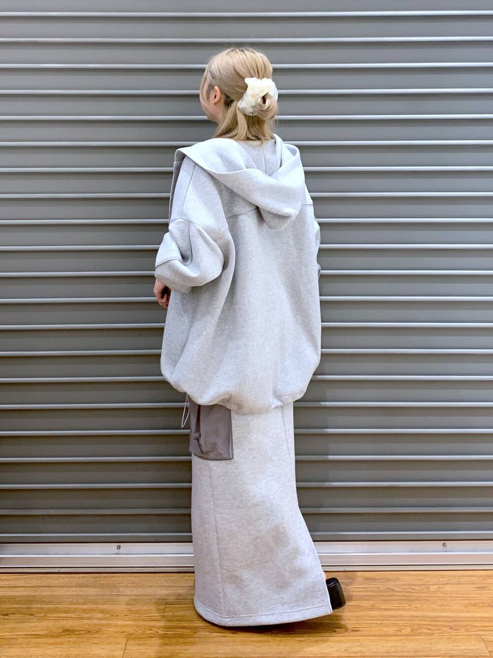 グレー系のブルゾン、ブラック系のニット/セーター、グレー系のスカートを着用したレディースの秋コーディネートの3枚目の写真