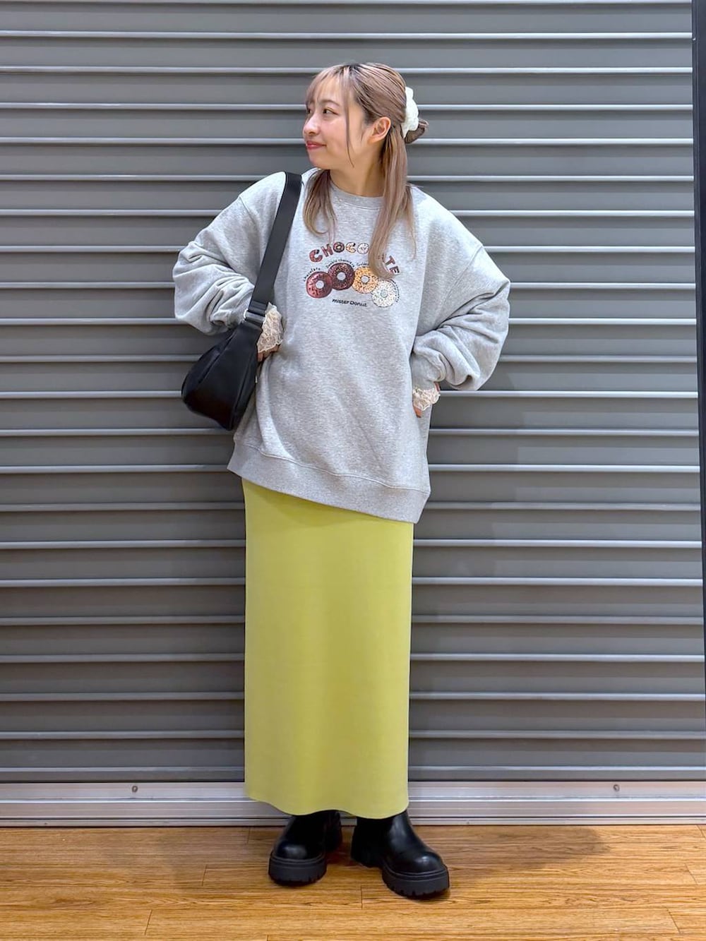 グリーン系のスカート、ブラック系のブーツ、グレー系のスウェットを着用したレディースの冬コーディネートの6枚目の写真