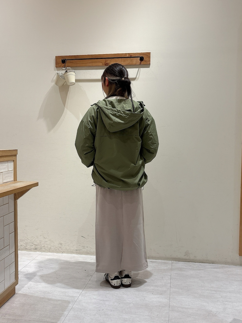 ホワイト系のTシャツ/カットソー、グリーン系のブルゾン、グレー系のスカートを着用したレディースの冬コーディネートの3枚目の写真