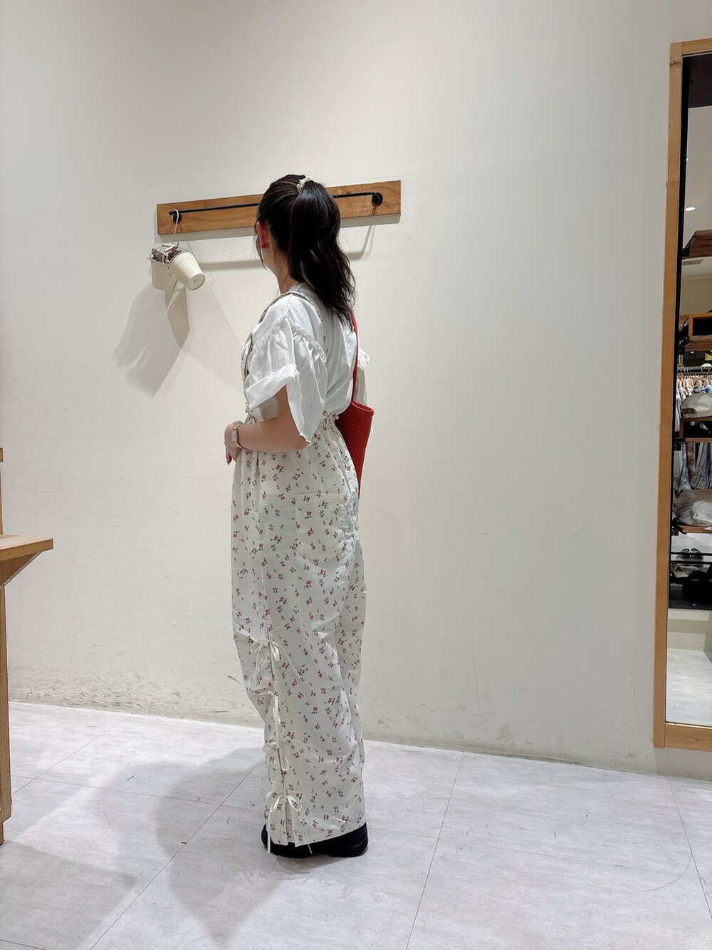 ホワイト系のTシャツ/カットソー、ホワイト系のオールインワン・サロペット、ブラック系のスニーカーを着用したレディースの春コーディネートの2枚目の写真