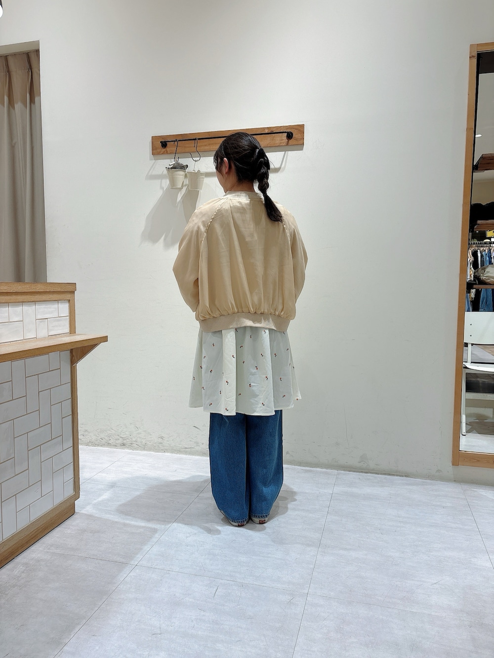 ベージュ系のブルゾン、ホワイト系のTシャツ/カットソー、ホワイト系のワンピースを着用したレディースの春コーディネートの3枚目の写真