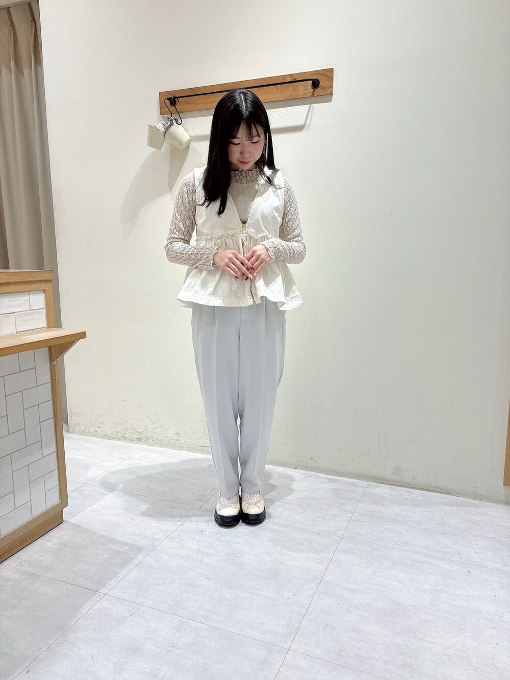 ホワイト系のTシャツ/カットソー、ホワイト系のベスト、グレー系のその他パンツを着用したレディースの冬コーディネートの5枚目の写真