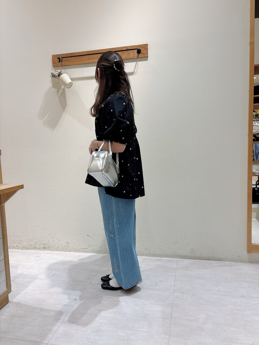 ブラック系のシャツ/ブラウス、ブルー系のデニムパンツ、シルバー系のハンドバッグを着用したレディースの春コーディネートの2枚目の写真