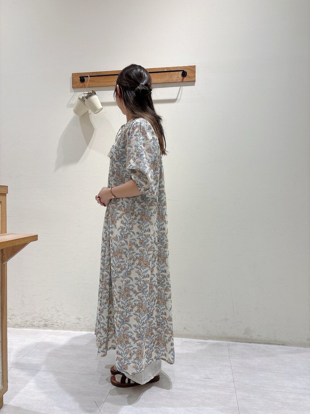 ホワイト系のワンピース/ドレス、ホワイト系のパンツ、ブラウン系のサンダルを着用したレディースの春コーディネートの2枚目の写真