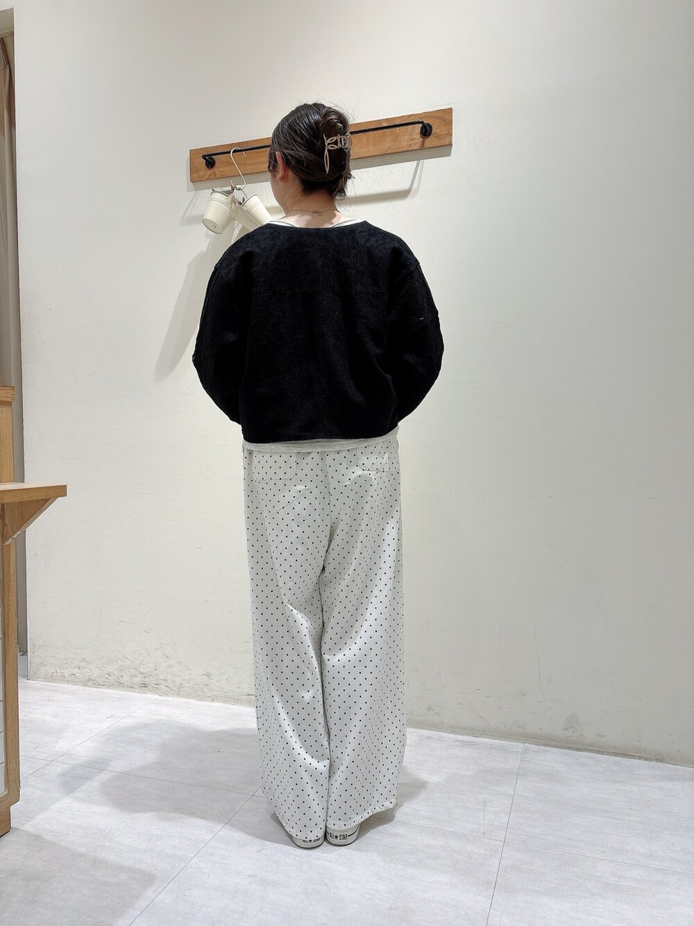 ブラック系のノーカラージャケット、グレー系のトップス、ホワイト系のパンツを着用したレディースの春コーディネートの3枚目の写真