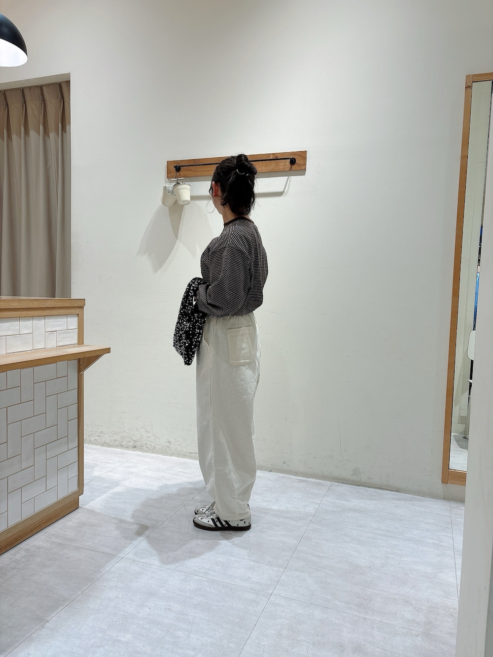 ブラウン系のTシャツ/カットソー、ブラック系のハンドバッグ、ホワイト系のその他パンツを着用したレディースの冬コーディネートの2枚目の写真