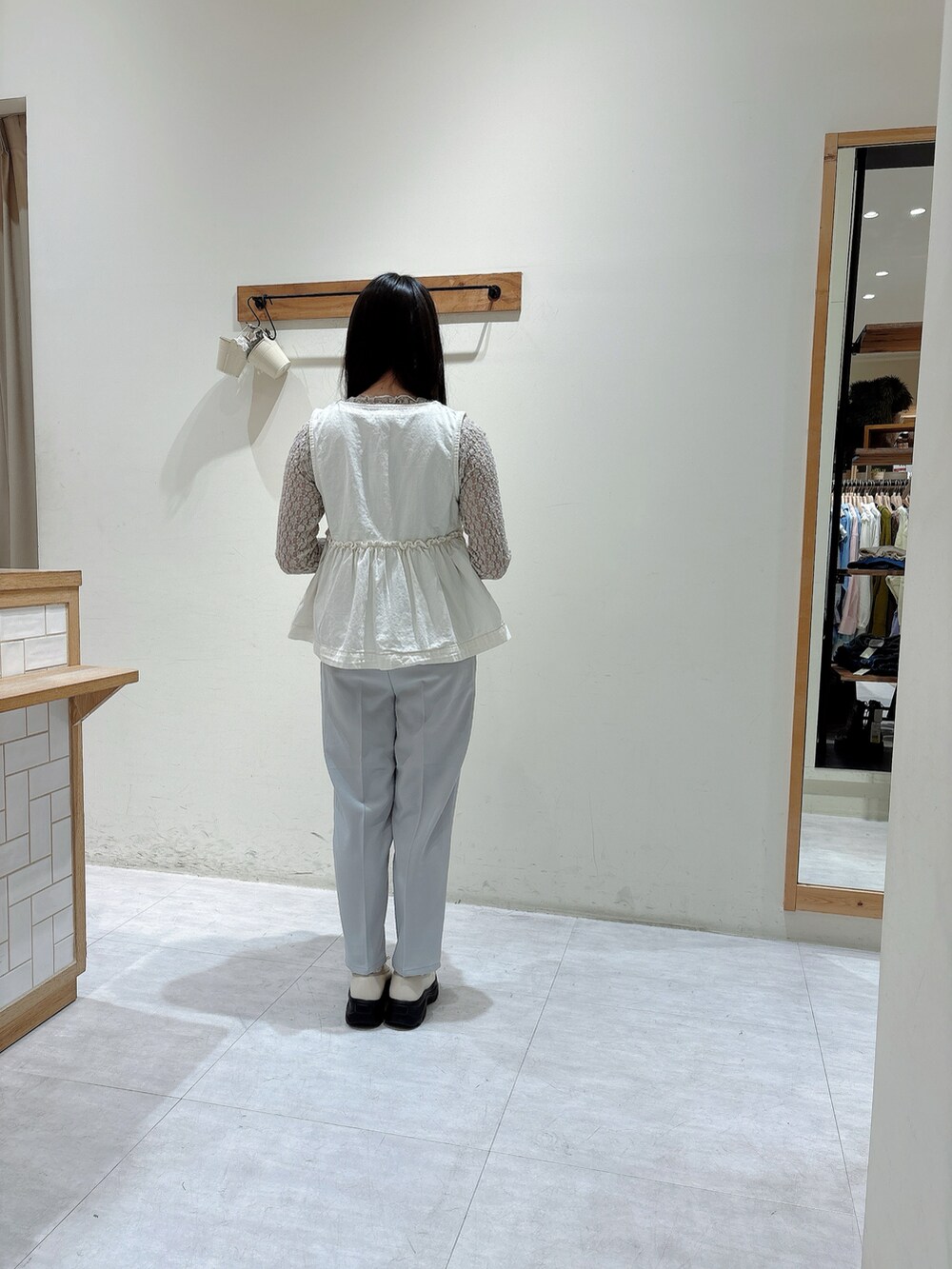 ホワイト系のTシャツ/カットソー、ホワイト系のベスト、グレー系のその他パンツを着用したレディースの冬コーディネートの3枚目の写真