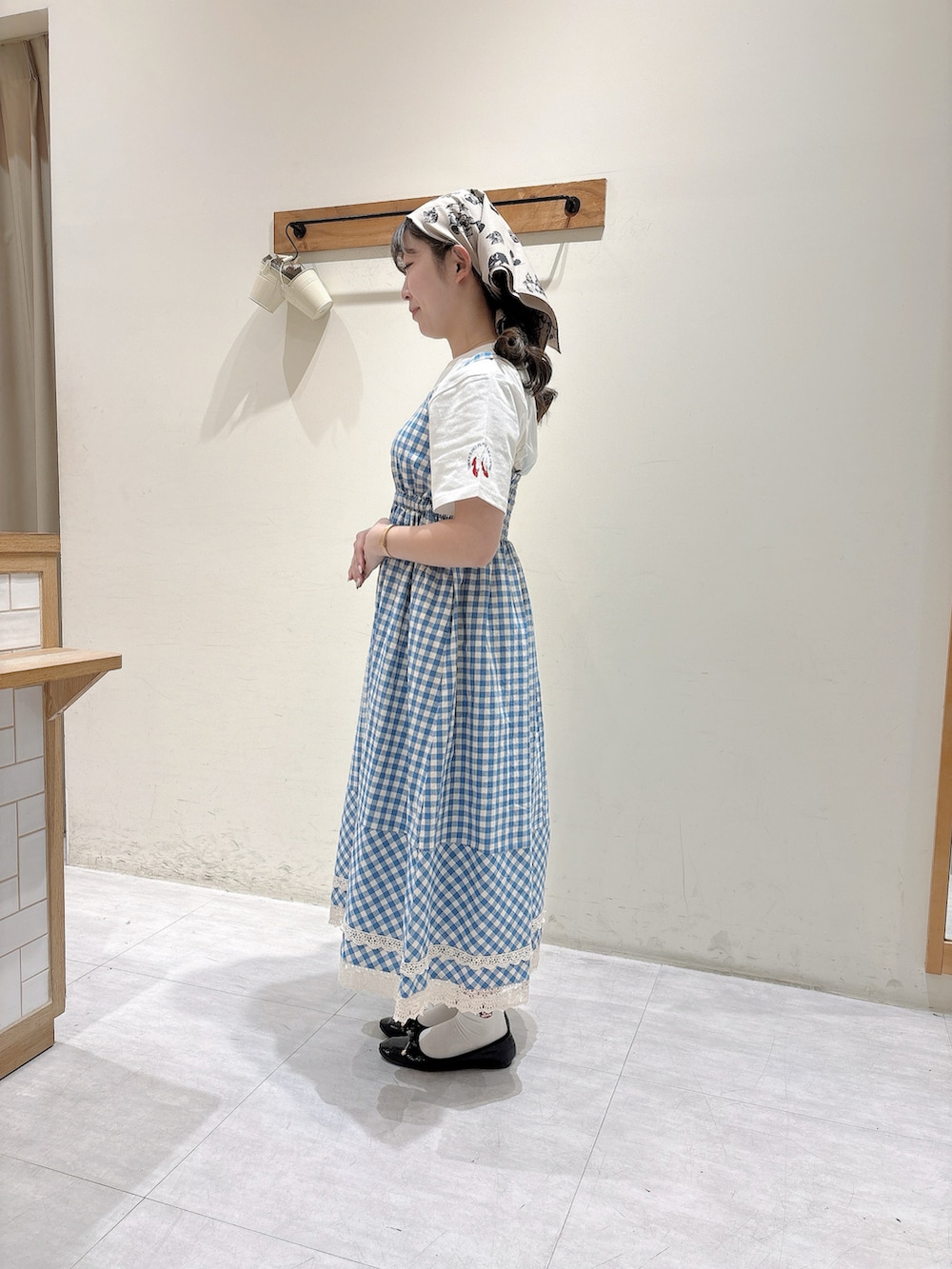 ホワイト系のTシャツ/カットソー、ブルー系のワンピース、ブラウン系のストール/ショールを着用したレディースの春コーディネートの2枚目の写真