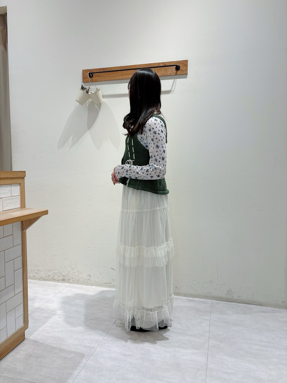 グリーン系のトップス、ホワイト系のトップス、ホワイト系のスカートを着用したレディースの春コーディネートの2枚目の写真