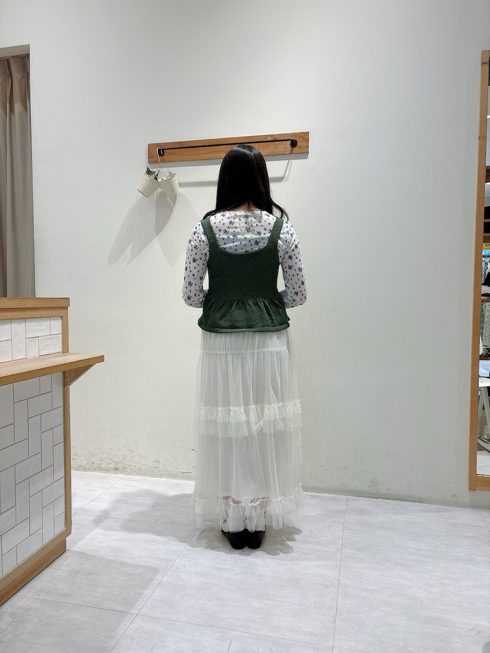 グリーン系のトップス、ホワイト系のトップス、ホワイト系のスカートを着用したレディースの春コーディネートの3枚目の写真