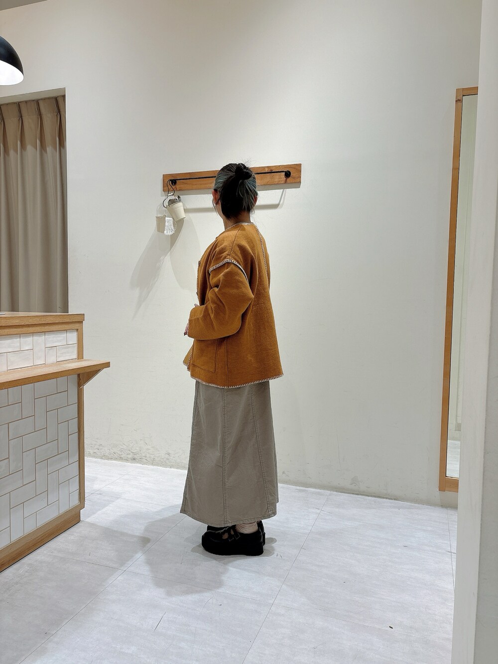 イエロー系のノーカラージャケット、ベージュ系のワンピース、グレー系のTシャツ/カットソーを着用したレディースの秋コーディネートの2枚目の写真