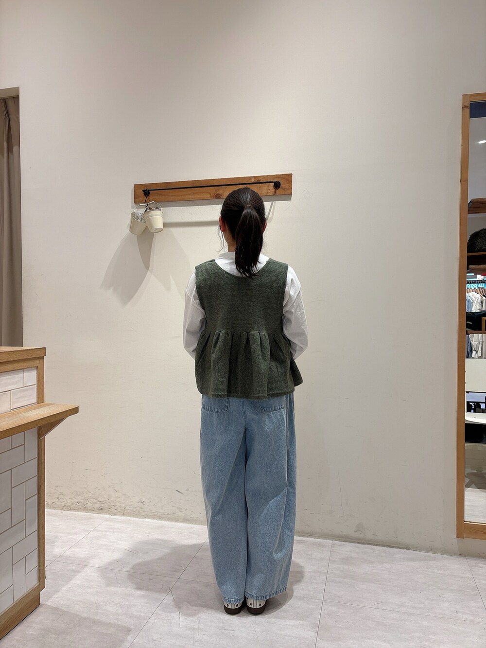 ホワイト系のTシャツ/カットソー、グリーン系のベスト、ブルー系のその他パンツを着用したレディースの冬コーディネートの3枚目の写真