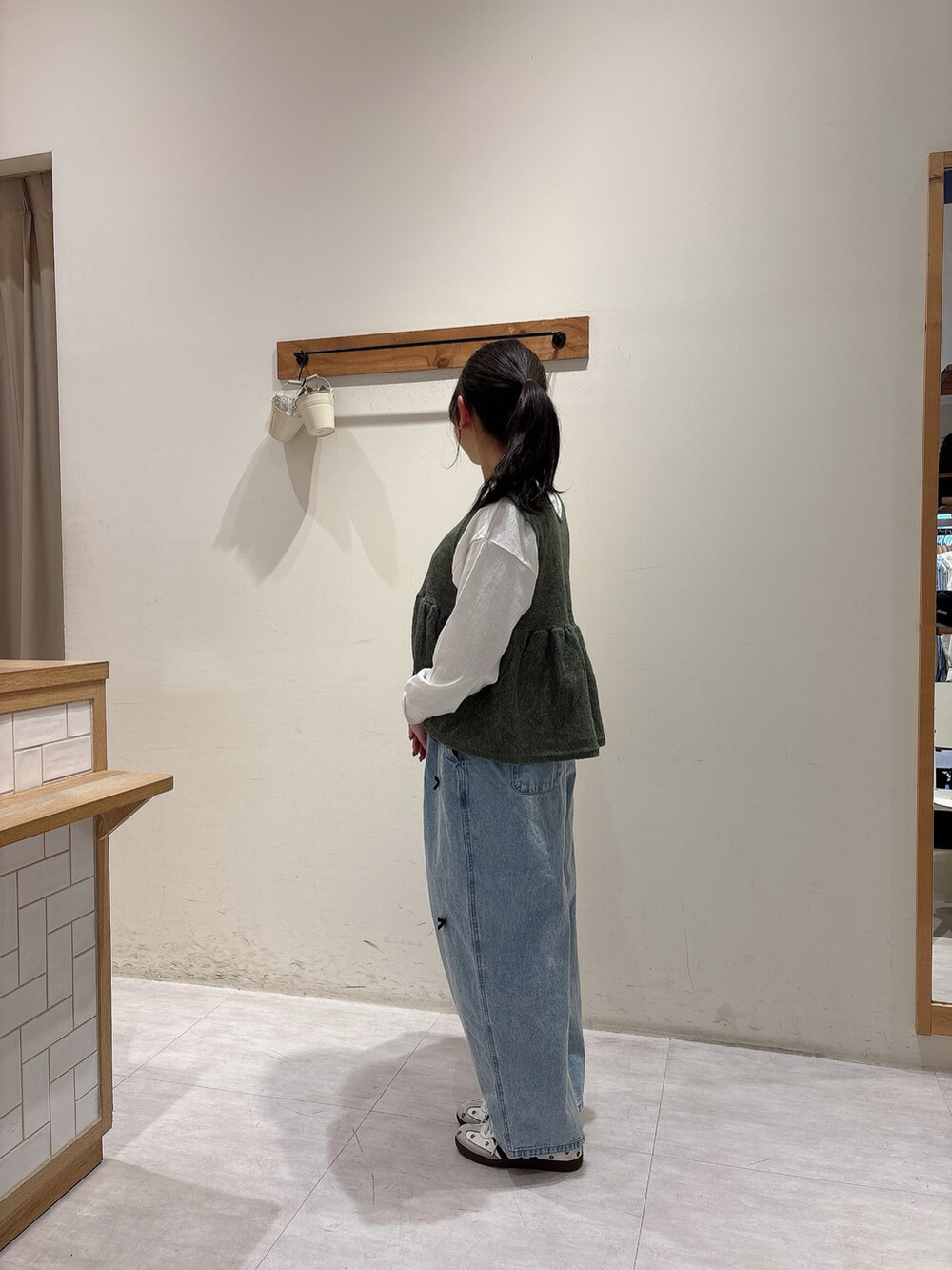 ホワイト系のTシャツ/カットソー、グリーン系のベスト、ブルー系のその他パンツを着用したレディースの冬コーディネートの2枚目の写真