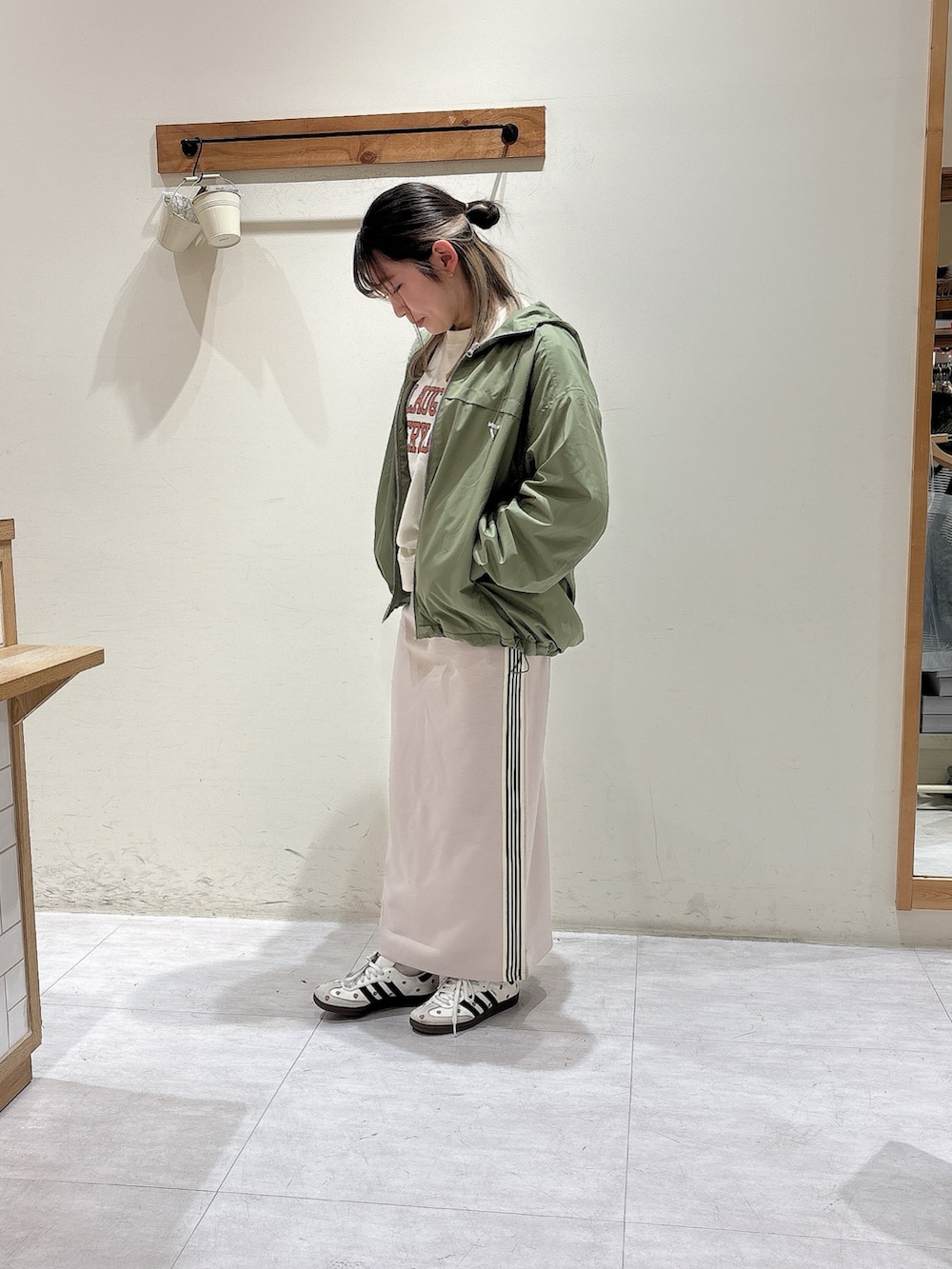 ホワイト系のTシャツ/カットソー、グリーン系のブルゾン、グレー系のスカートを着用したレディースの冬コーディネートの2枚目の写真