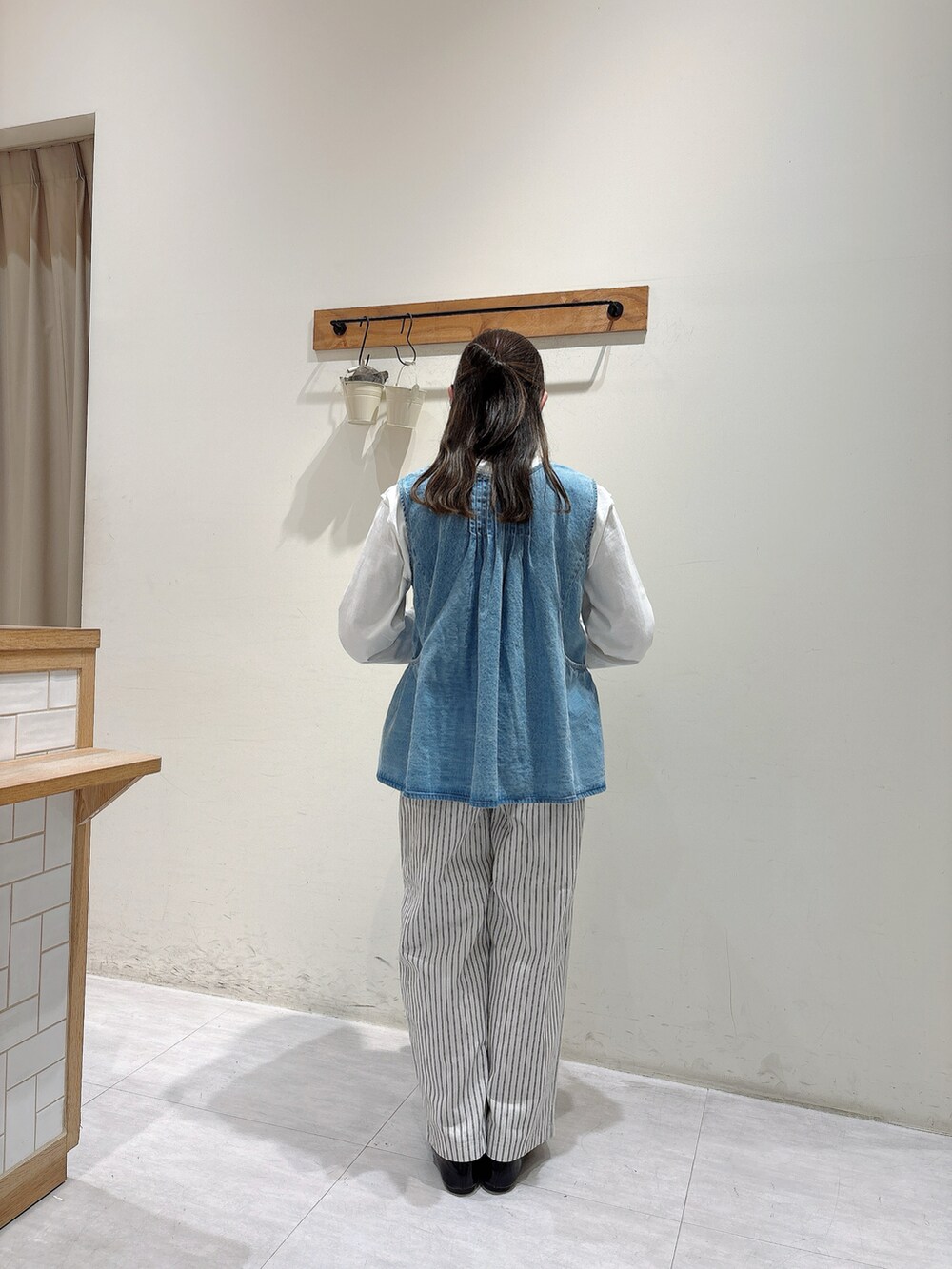 ホワイト系のTシャツ/カットソー、ブルー系のベスト、ホワイト系のその他パンツを着用したレディースの春コーディネートの3枚目の写真