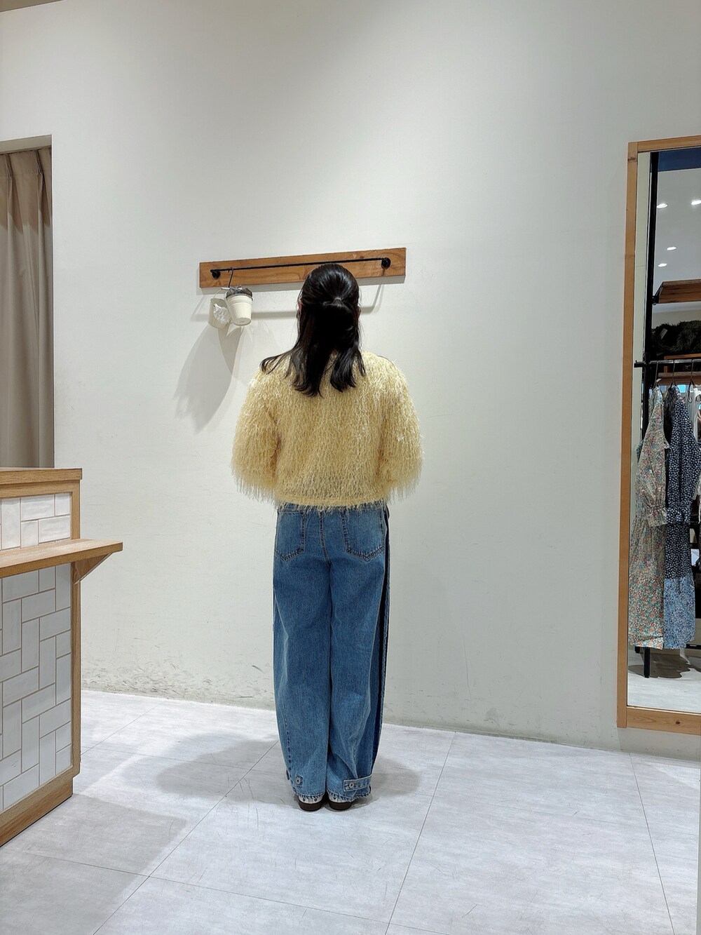 イエロー系のカーディガン/ボレロ、ホワイト系のTシャツ/カットソー、ブルー系のその他パンツを着用したレディースの冬コーディネートの3枚目の写真