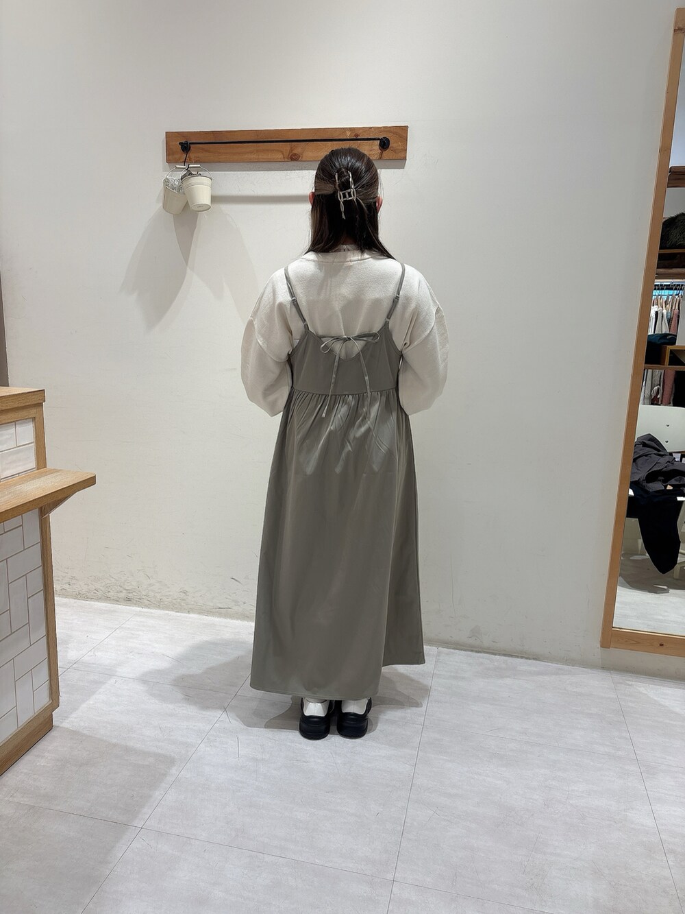 ホワイト系のニット/セーター、グリーン系のワンピース、ホワイト系のスニーカーを着用したレディースの冬コーディネートの3枚目の写真