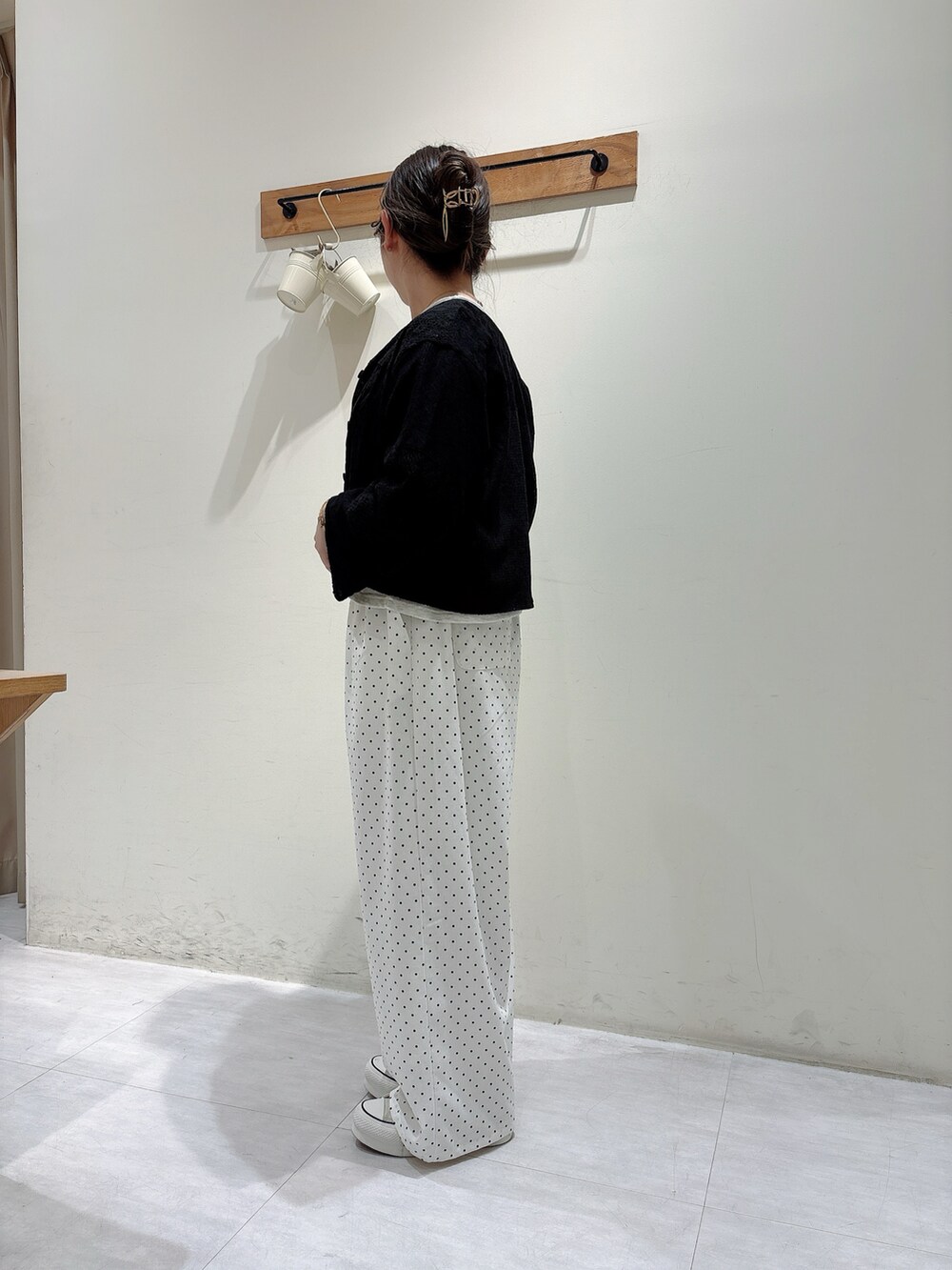 ブラック系のノーカラージャケット、グレー系のトップス、ホワイト系のパンツを着用したレディースの春コーディネートの2枚目の写真