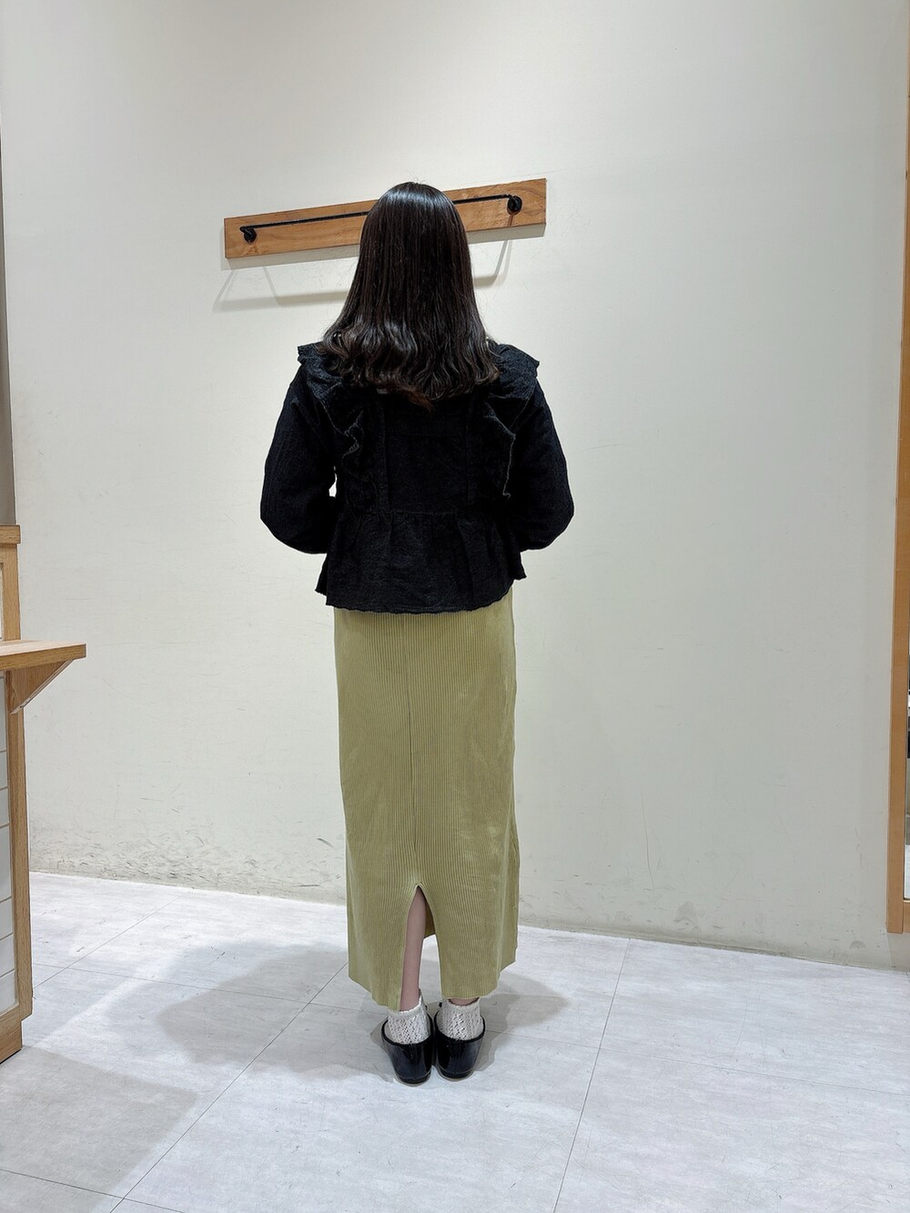 ブラック系のシャツ/ブラウス、ホワイト系のTシャツ/カットソー、グリーン系のスカートを着用したレディースの春コーディネートの3枚目の写真