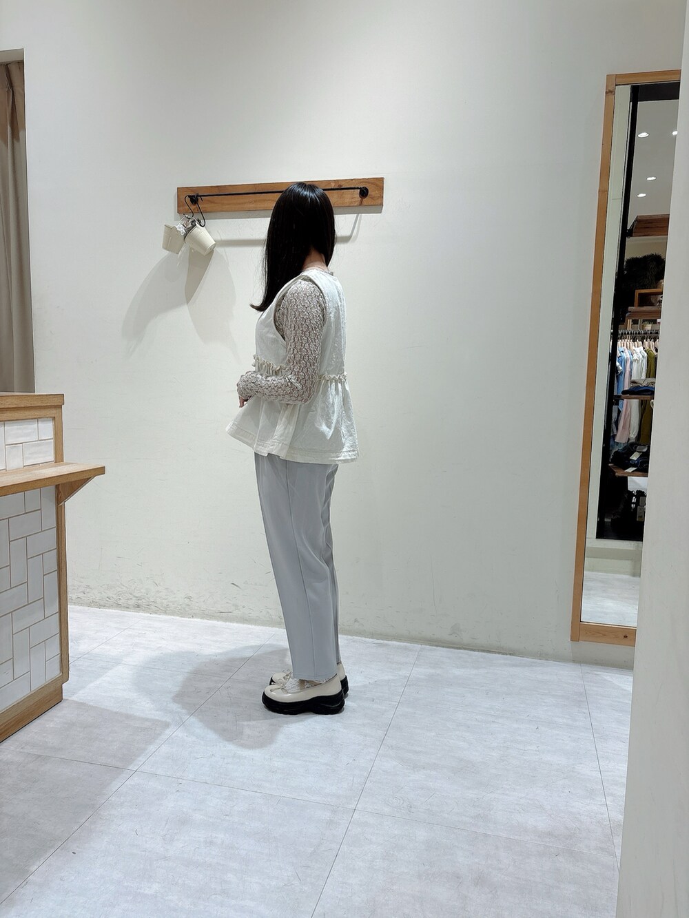 ホワイト系のTシャツ/カットソー、ホワイト系のベスト、グレー系のその他パンツを着用したレディースの冬コーディネートの2枚目の写真