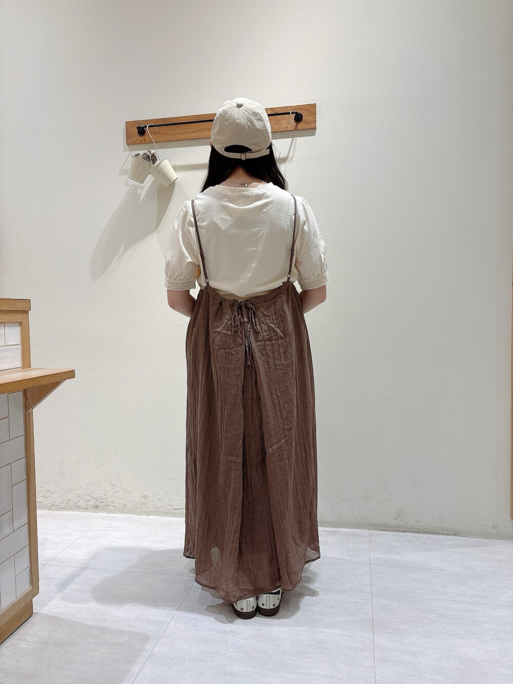 ブラウン系のワンピース、ホワイト系のTシャツ/カットソー、ベージュ系のハットを着用したレディースの夏コーディネートの3枚目の写真