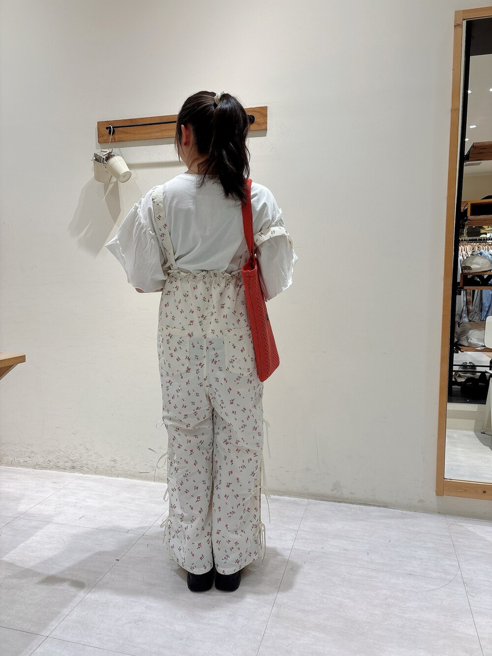 ホワイト系のTシャツ/カットソー、ホワイト系のオールインワン・サロペット、ブラック系のスニーカーを着用したレディースの春コーディネートの3枚目の写真