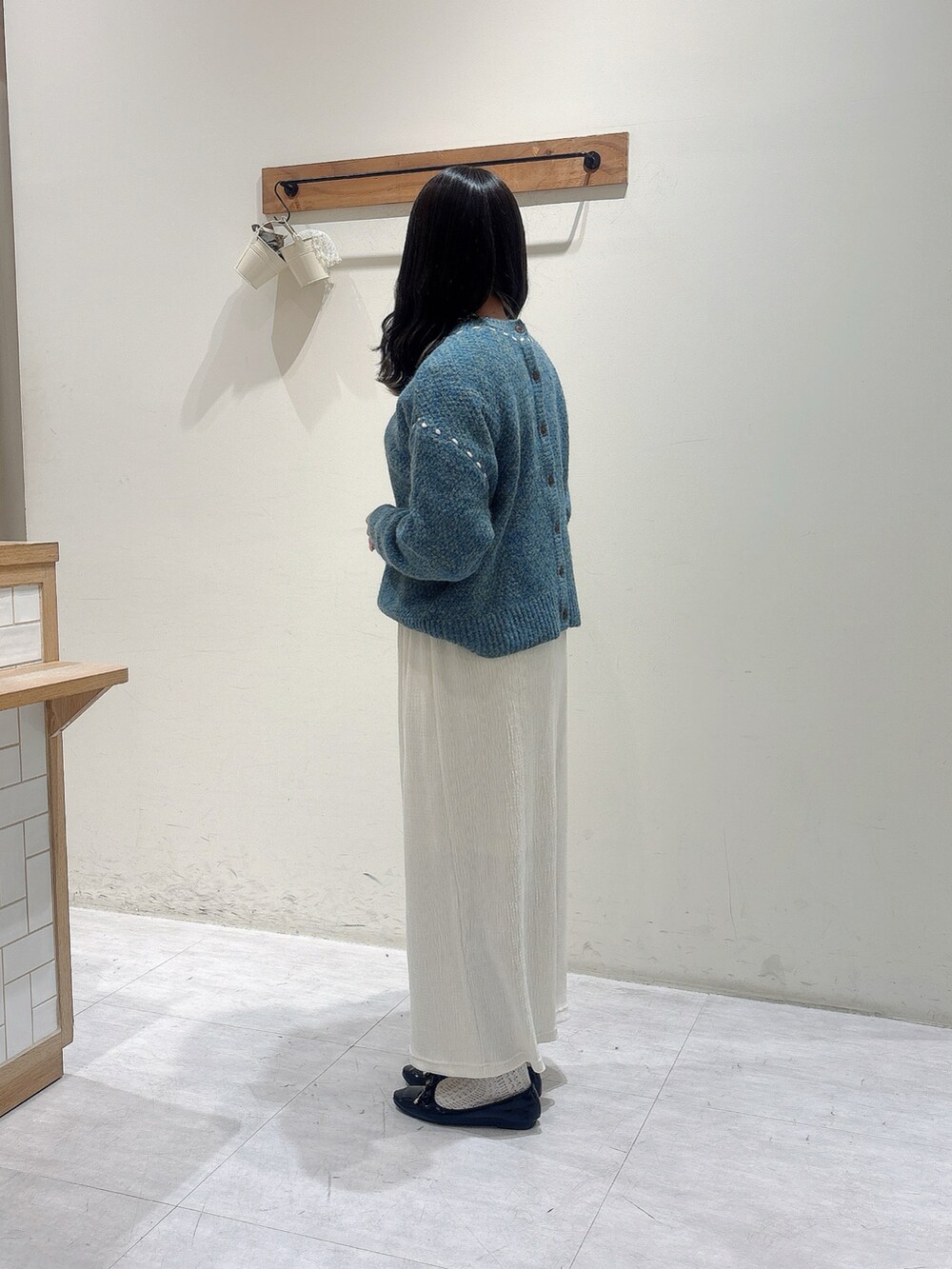 ブルー系のカーディガン/ボレロ、ホワイト系のシャツ/ブラウス、ホワイト系のスカートを着用したレディースの冬コーディネートの2枚目の写真