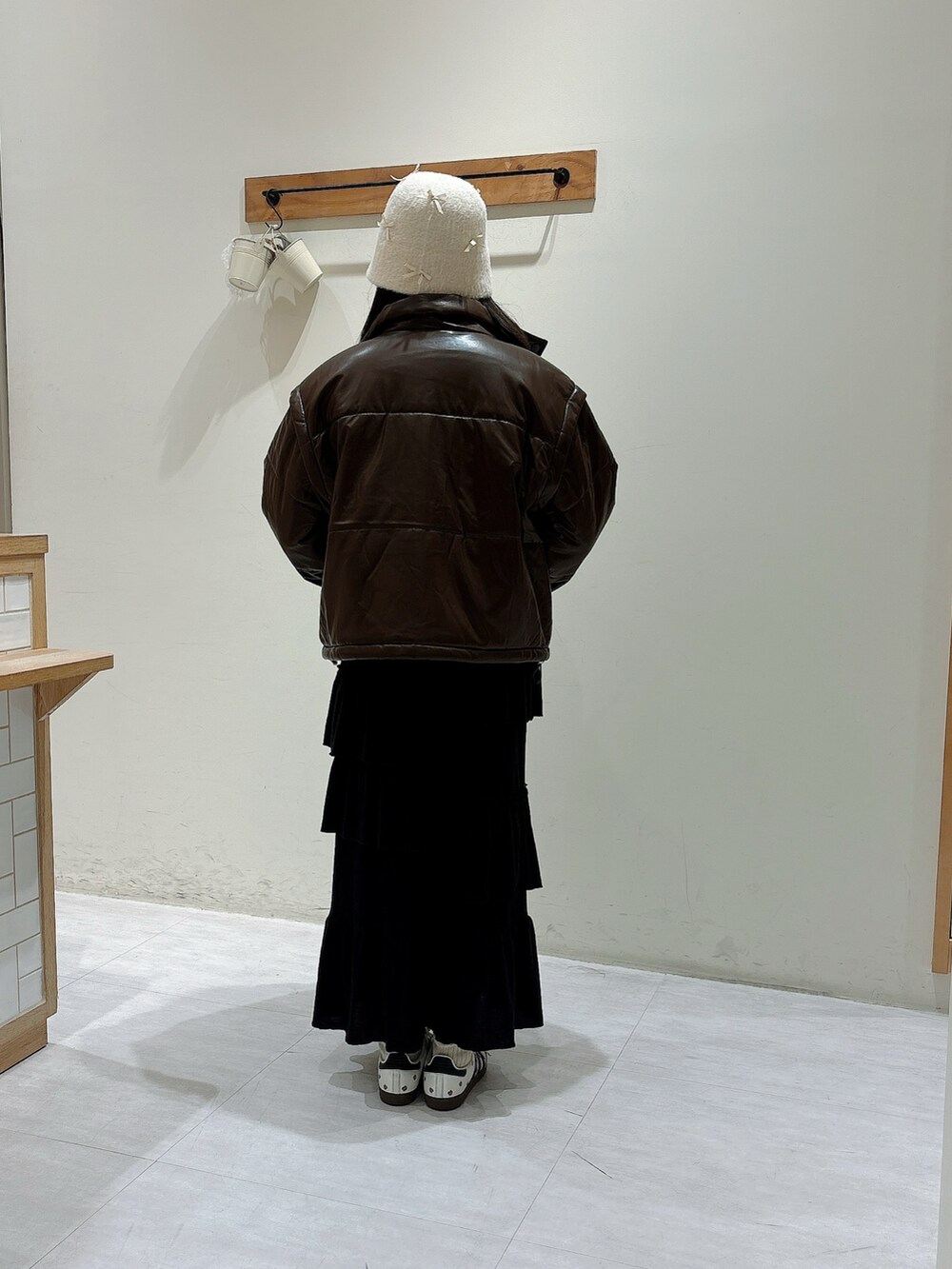 ブラウン系のノーカラージャケット、ブラック系のスカート、ホワイト系のニット/セーターを着用したレディースの秋コーディネートの3枚目の写真