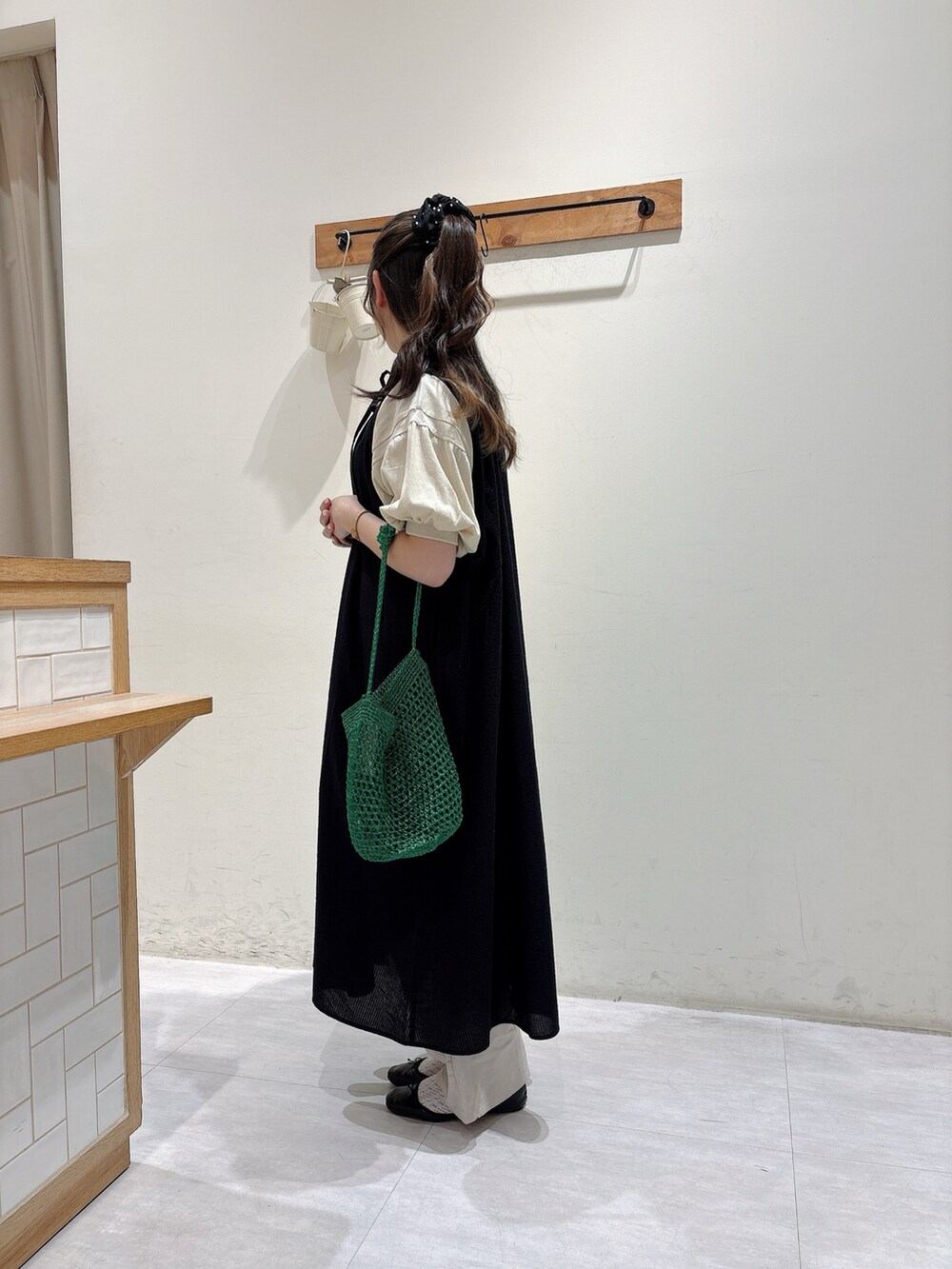 ベージュ系のTシャツ/カットソー、ブラック系のワンピース/ドレス、ベージュ系のパンツを着用したレディースの夏コーディネートの2枚目の写真