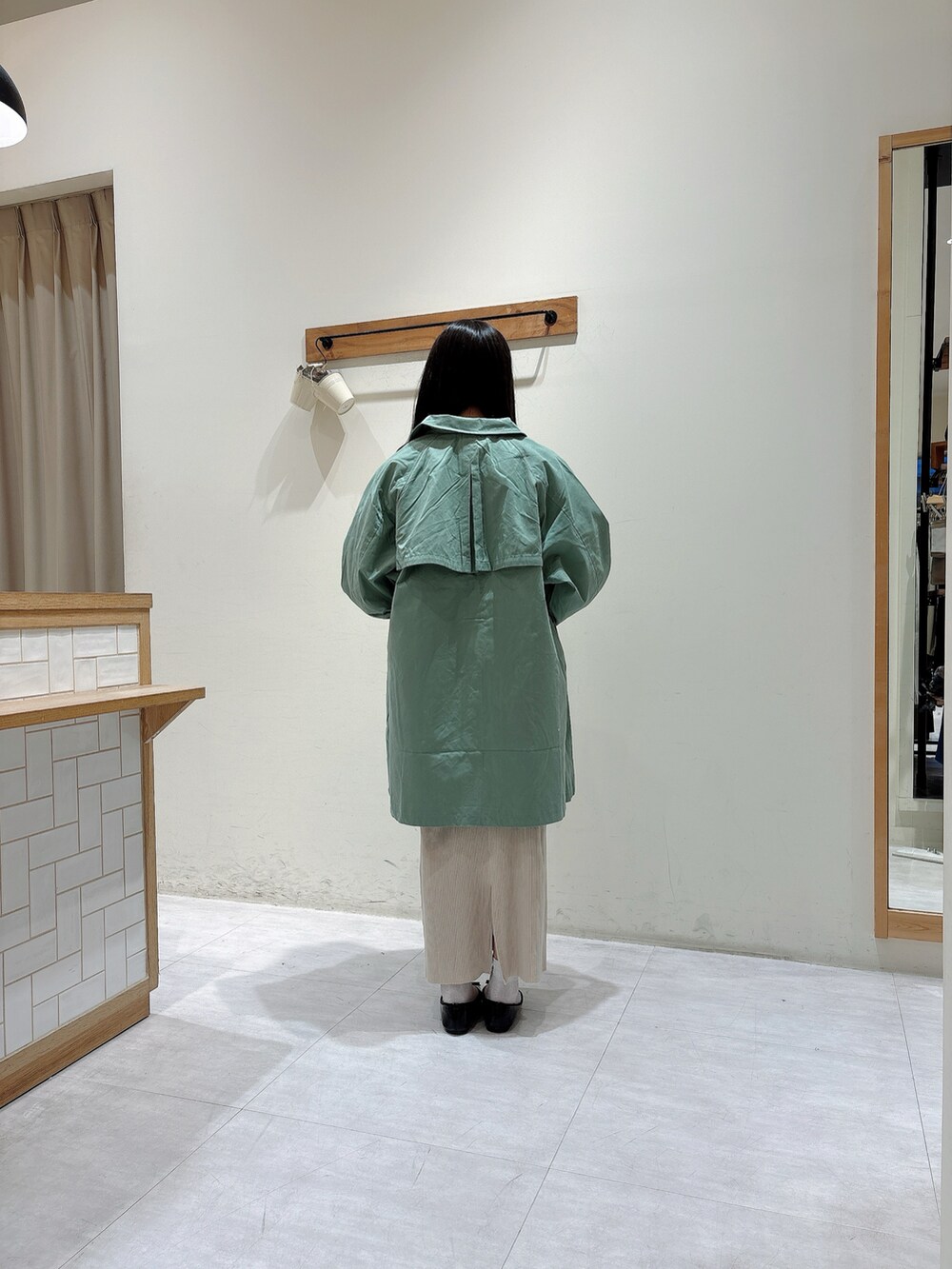 ホワイト系のシャツ/ブラウス、グリーン系のジャケット/アウター、ホワイト系のスカートを着用したレディースの春コーディネートの3枚目の写真