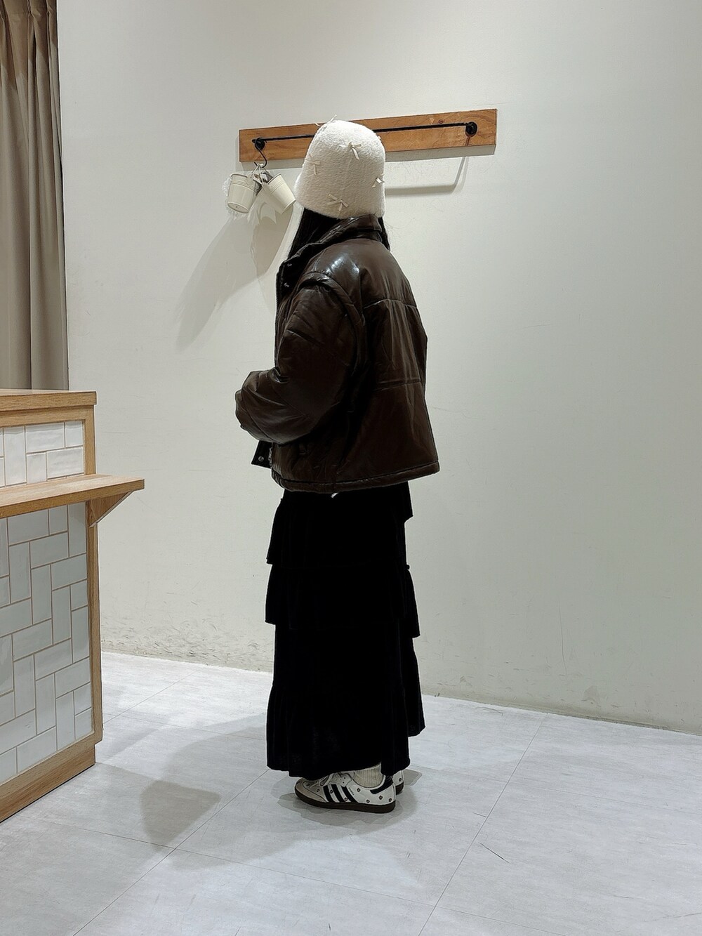 ブラウン系のノーカラージャケット、ブラック系のスカート、ホワイト系のニット/セーターを着用したレディースの秋コーディネートの2枚目の写真