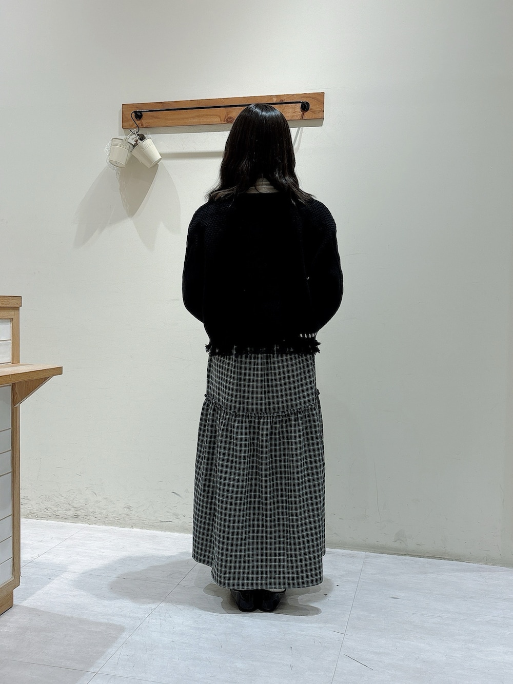 ブラック系のニット/セーター、ブルー系のワンピース、ホワイト系のTシャツ/カットソーを着用したレディースの秋コーディネートの3枚目の写真