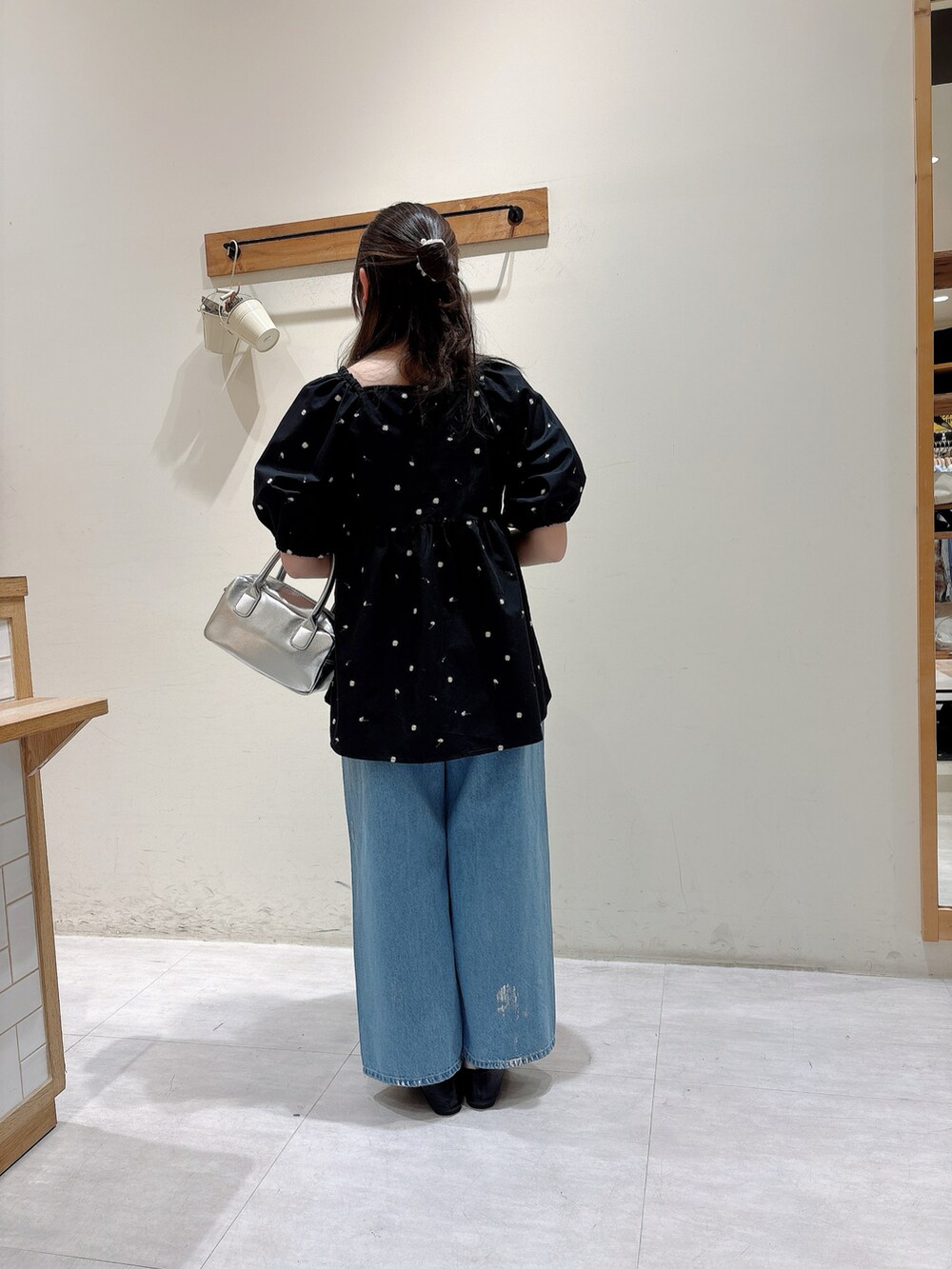 ブラック系のシャツ/ブラウス、ブルー系のデニムパンツ、シルバー系のハンドバッグを着用したレディースの春コーディネートの3枚目の写真