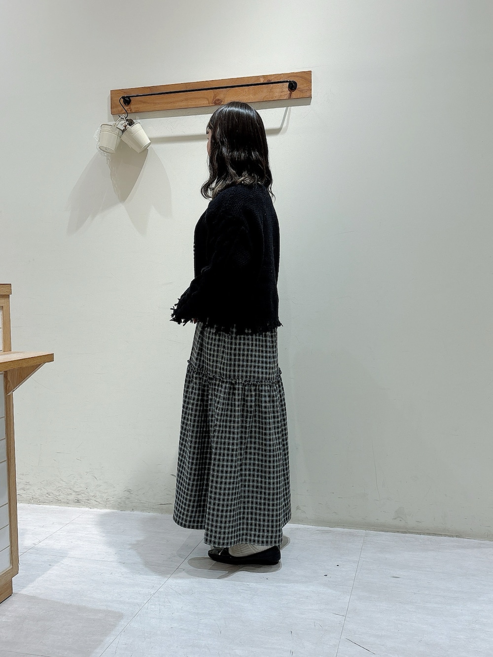 ブラック系のニット/セーター、ブルー系のワンピース、ホワイト系のTシャツ/カットソーを着用したレディースの秋コーディネートの2枚目の写真