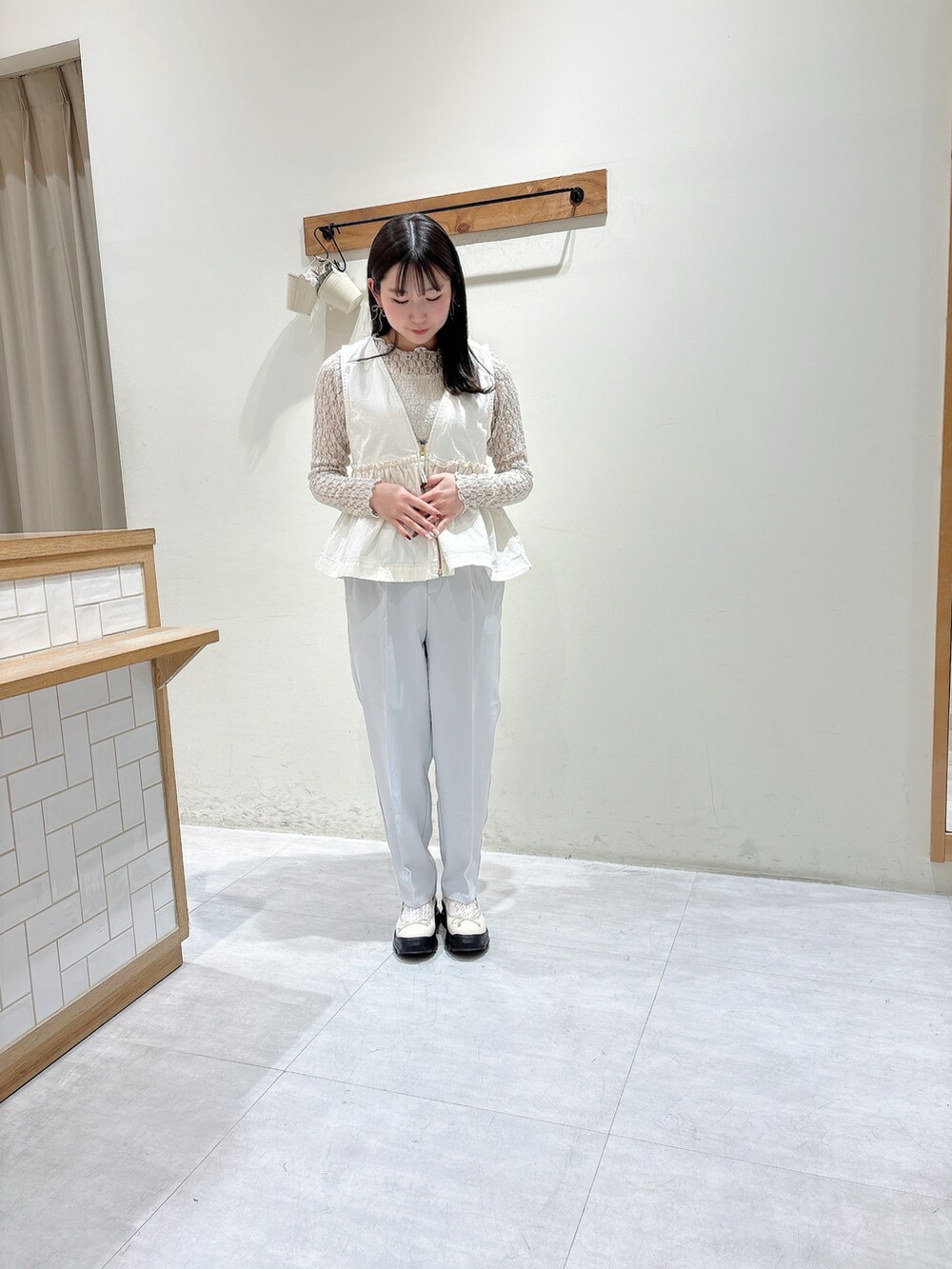 ホワイト系のTシャツ/カットソー、ホワイト系のベスト、グレー系のその他パンツを着用したレディースの冬コーディネートの4枚目の写真