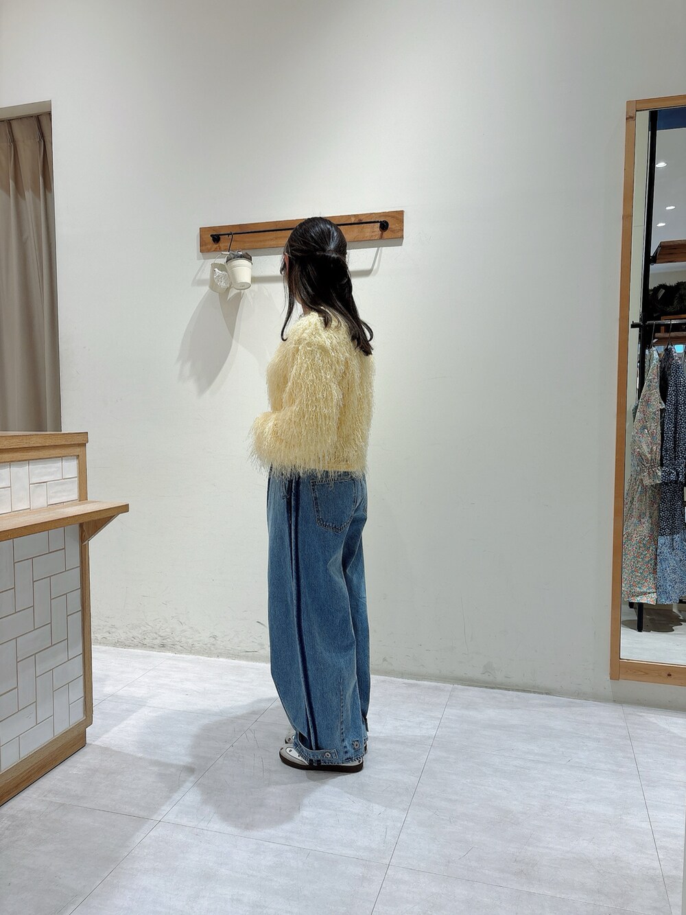 イエロー系のカーディガン/ボレロ、ホワイト系のTシャツ/カットソー、ブルー系のその他パンツを着用したレディースの冬コーディネートの2枚目の写真