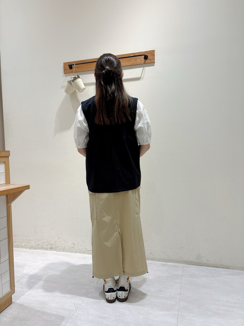 ホワイト系のシャツ/ブラウス、ブラック系のベスト、ベージュ系のスカートを着用したレディースの春コーディネートの3枚目の写真