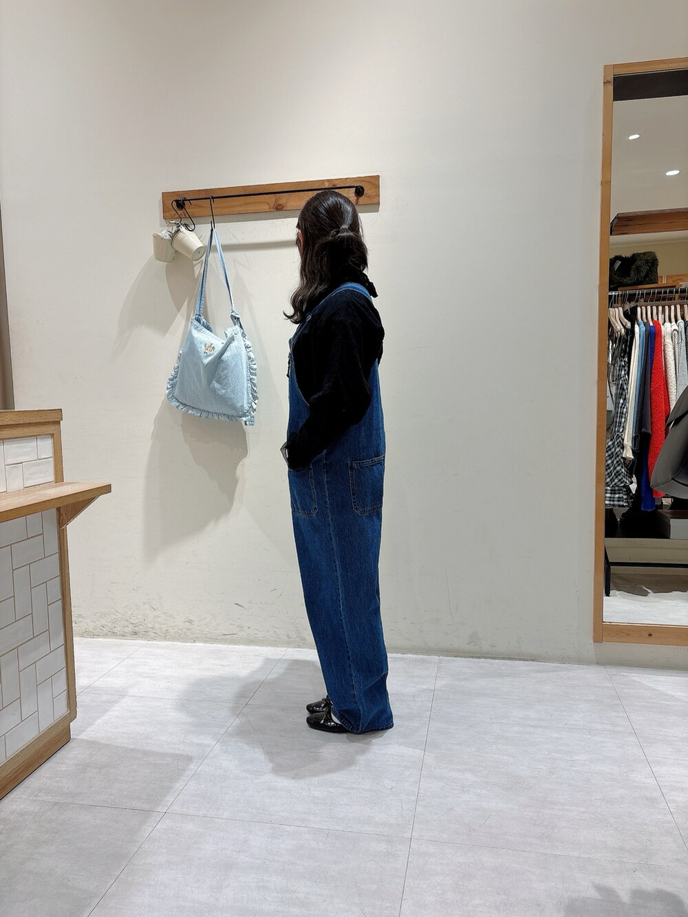 ブルー系のオールインワン・サロペット、ブラック系のシャツ/ブラウスを着用したレディースの冬コーディネートの2枚目の写真