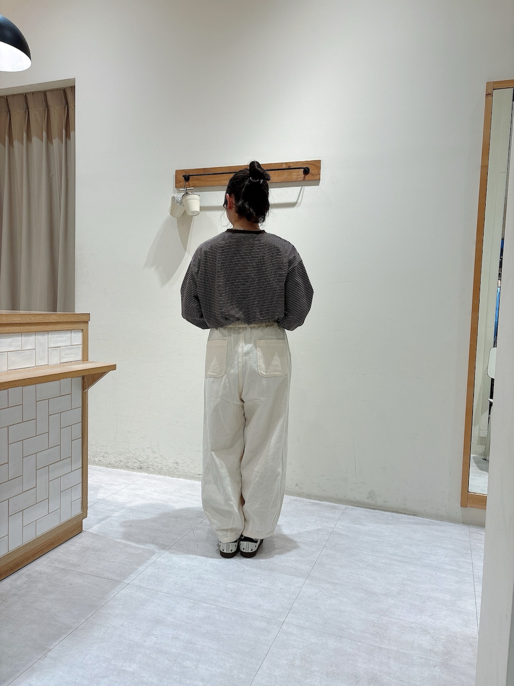 ブラウン系のTシャツ/カットソー、ブラック系のハンドバッグ、ホワイト系のその他パンツを着用したレディースの冬コーディネートの3枚目の写真