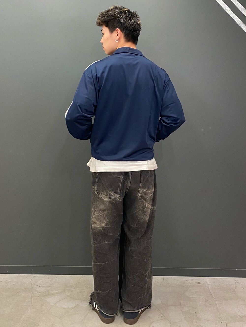 ブルー系のジャージ、ブラック系のスニーカーを着用したメンズの春コーディネートの2枚目の写真