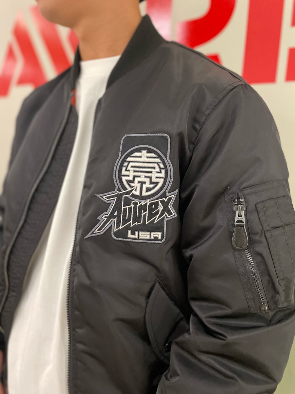 ホワイト系のTシャツ/カットソー、ブラック系のMA-1、ブラック系のニットキャップ/ビーニーを着用したメンズの冬コーディネートの3枚目の写真