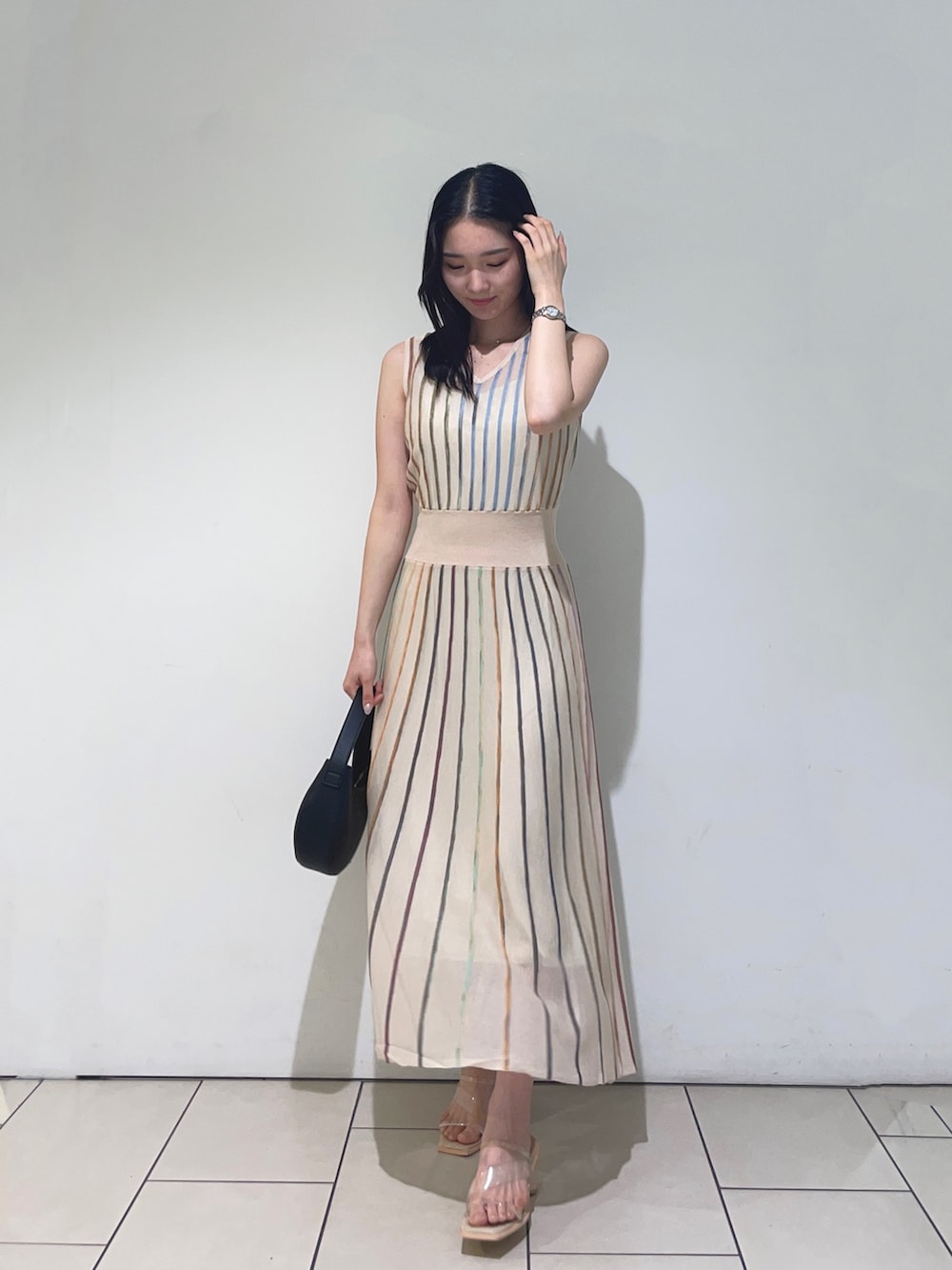 ホワイト系のワンピース、ブラック系のハンドバッグを着用したレディースの春コーディネートの3枚目の写真