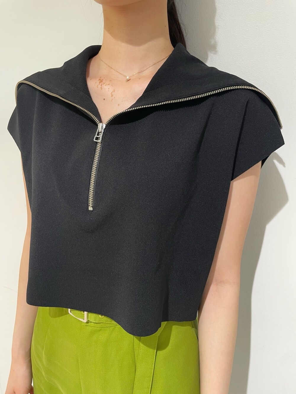 ブラック系のニット/セーター、グリーン系のその他パンツ、ブラック系のハンドバッグを着用したレディースの春コーディネートの6枚目の写真