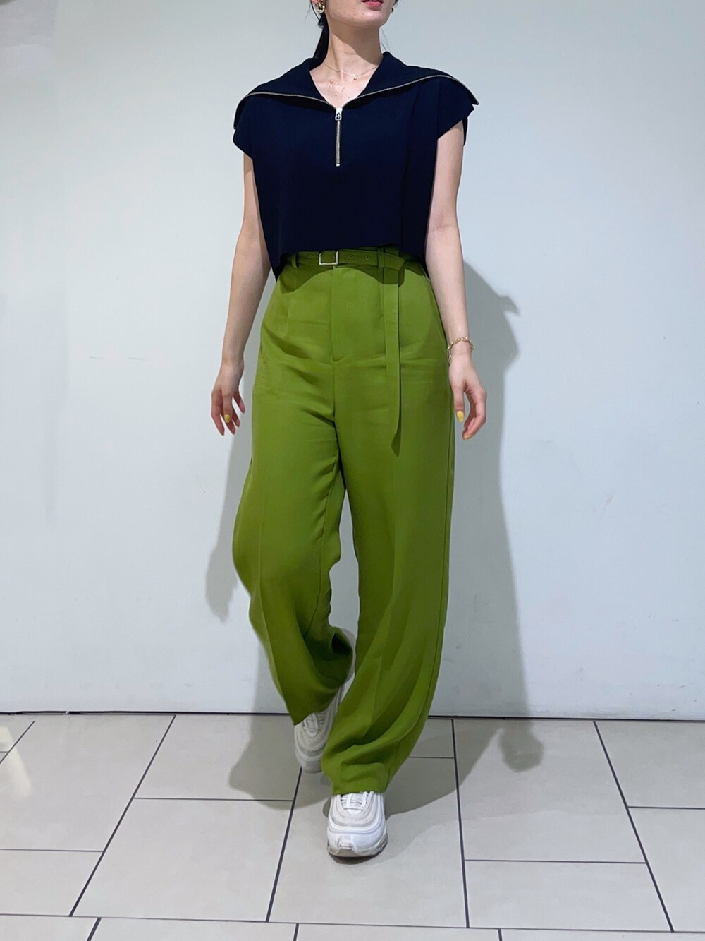 ブラック系のニット/セーター、グリーン系のその他パンツ、ブラック系のハンドバッグを着用したレディースの春コーディネートの5枚目の写真