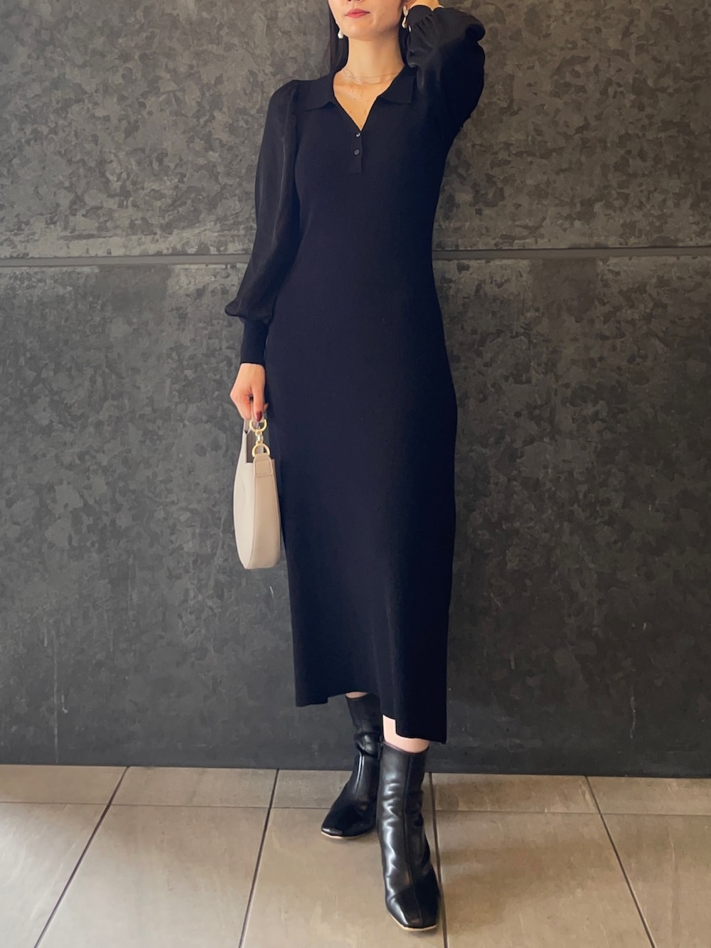 ホワイト系のハンドバッグ、ブラック系のブーツ、ブラック系のワンピースを着用したレディースの秋コーディネートの2枚目の写真