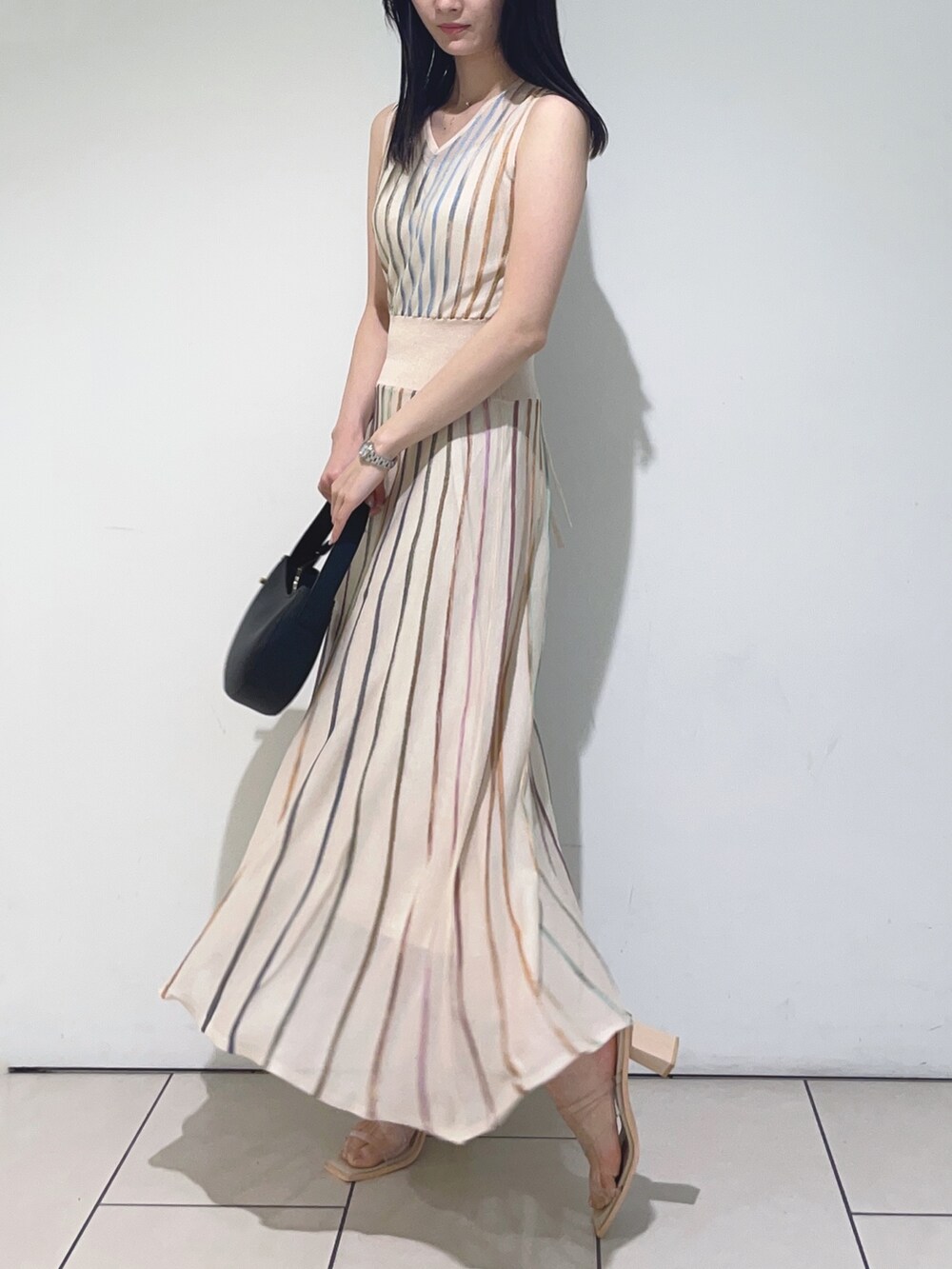 ホワイト系のワンピース、ブラック系のハンドバッグを着用したレディースの春コーディネートの4枚目の写真