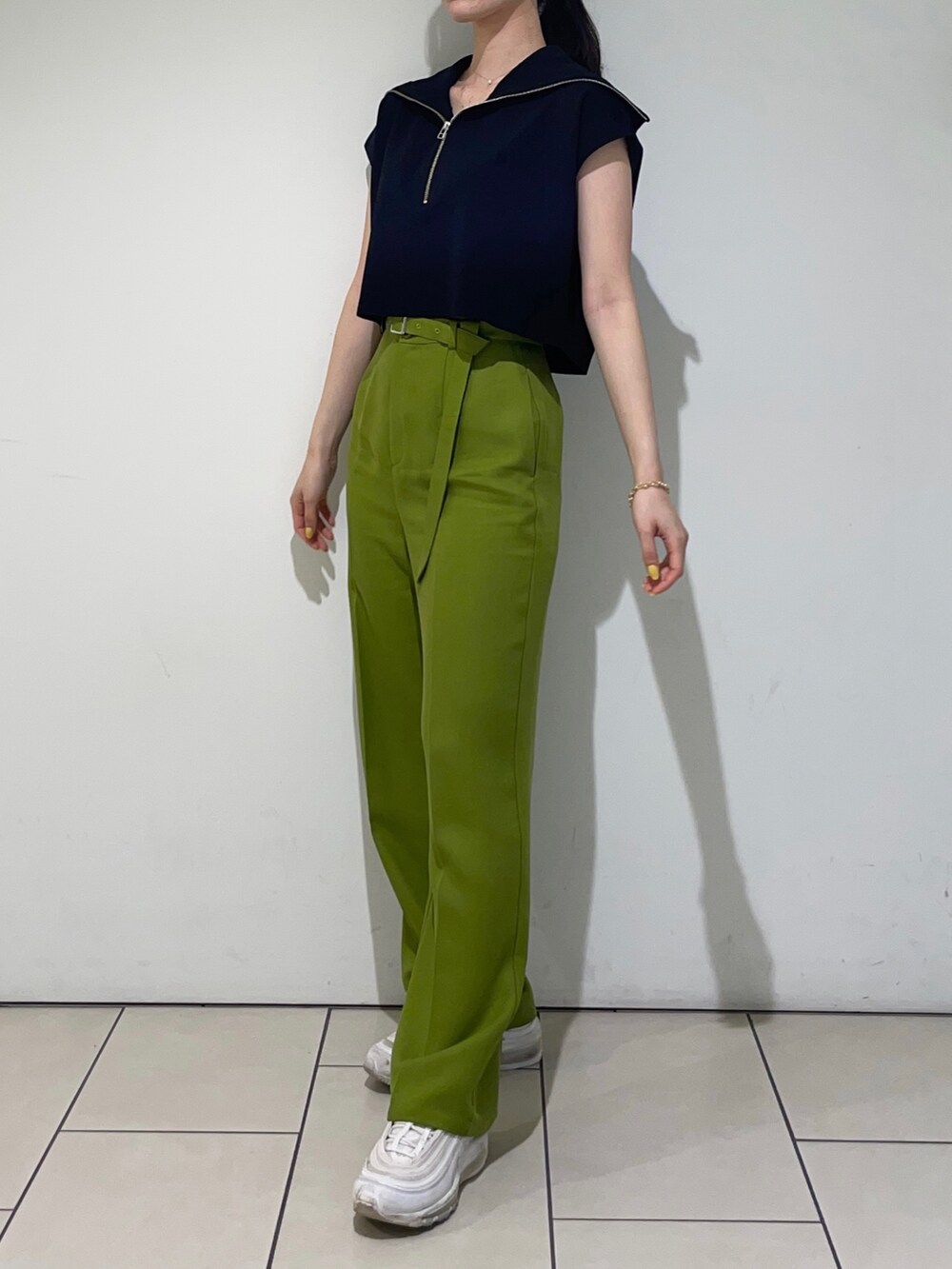 ブラック系のニット/セーター、グリーン系のその他パンツ、ブラック系のハンドバッグを着用したレディースの春コーディネートの4枚目の写真