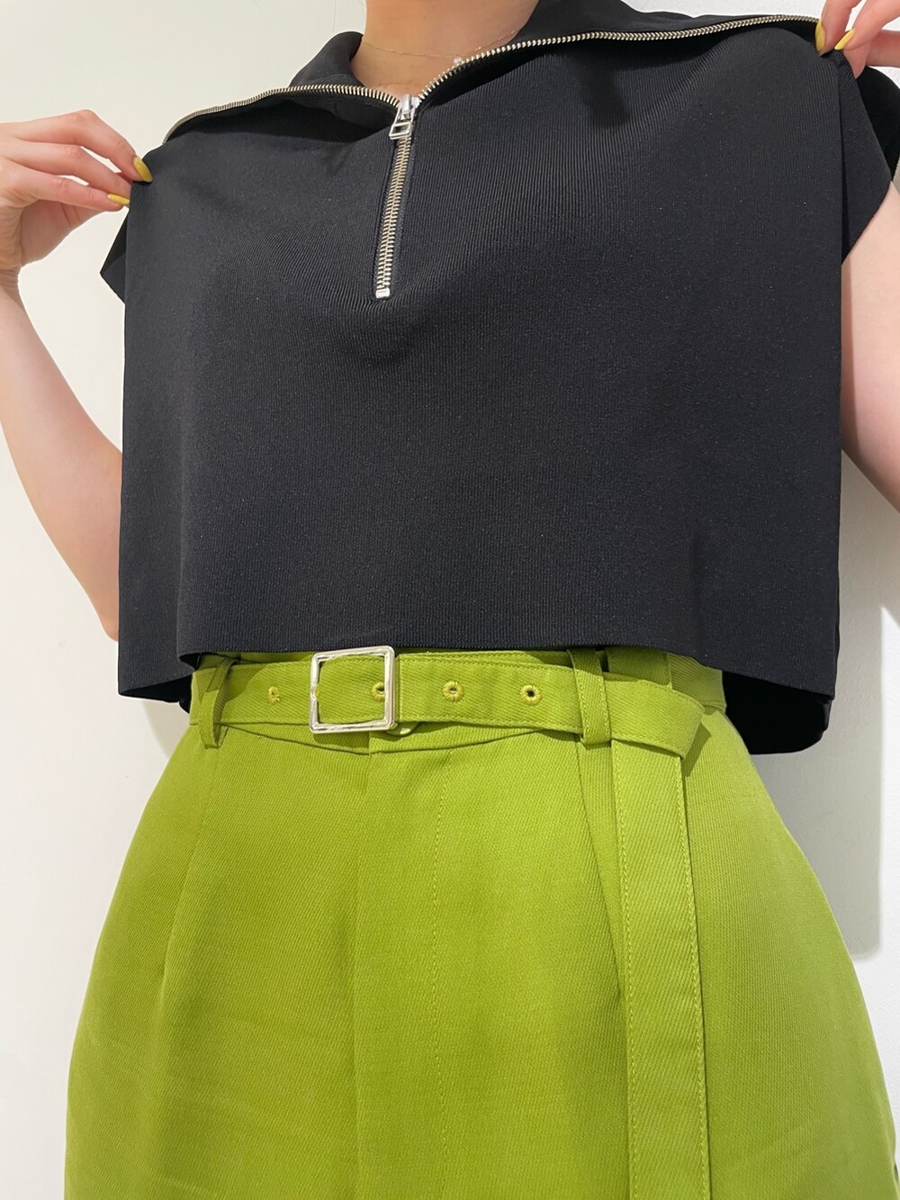 ブラック系のニット/セーター、グリーン系のその他パンツ、ブラック系のハンドバッグを着用したレディースの春コーディネートの7枚目の写真